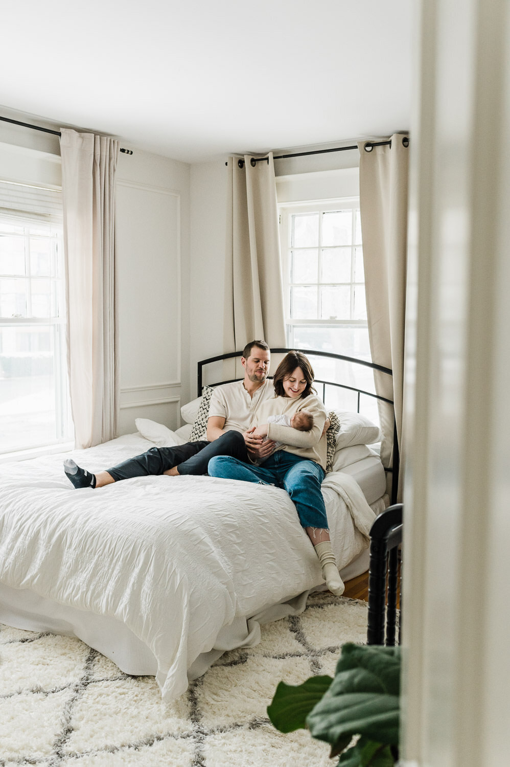 Couple holding new baby on bed in Halifax.