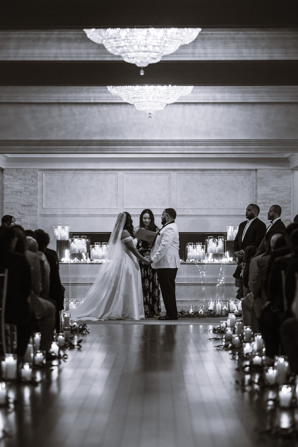 Bride and groom at the alter with candlelit aisle