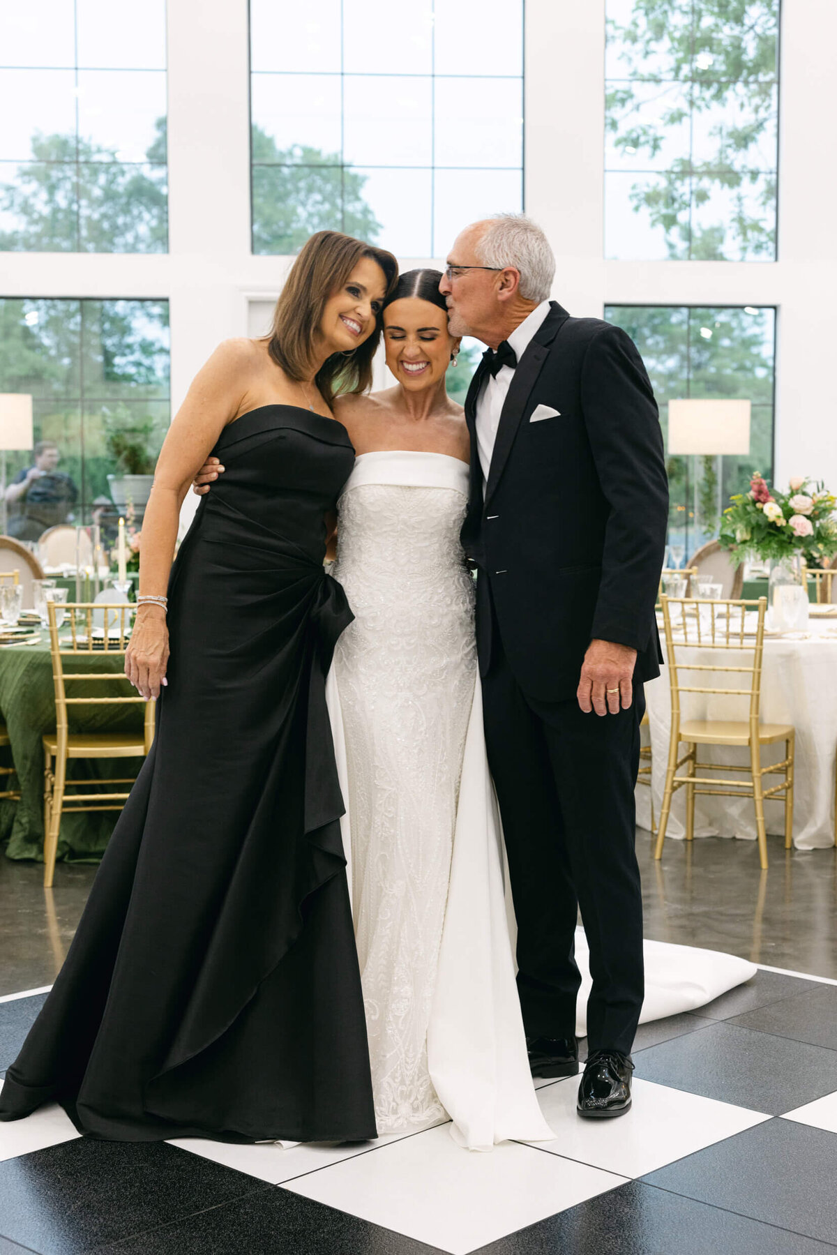 A wedding day photo of the bride in her white dress with her parents