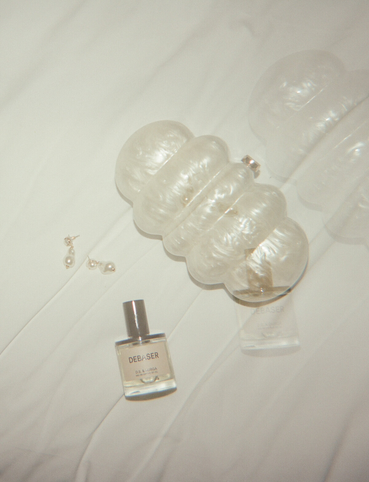 Film double exposure wedding photography of bridal details, perfume, baroque pearl wedding earrings, pearl clutch