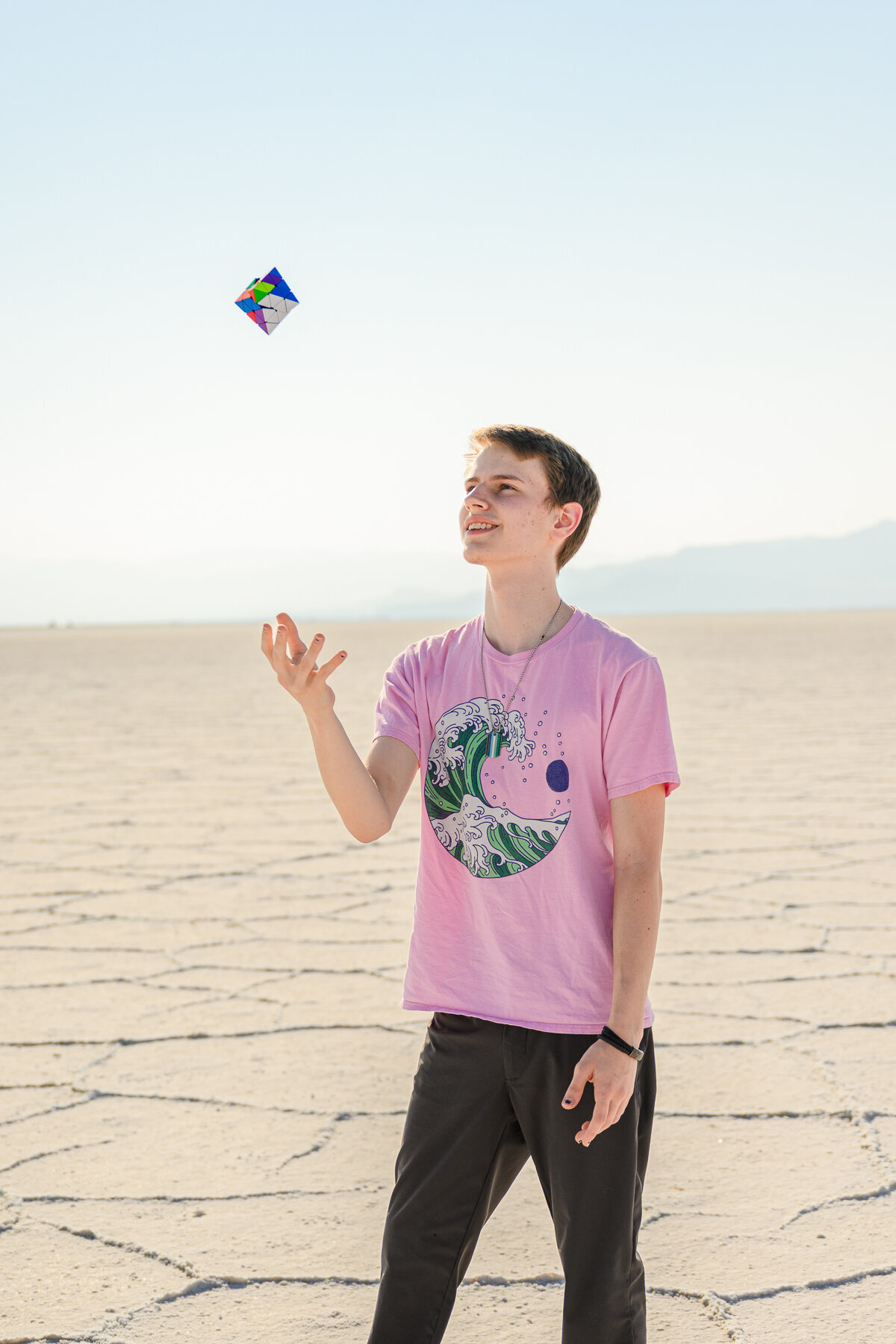 teen throws rubix cube for senior photos at salt flats utah