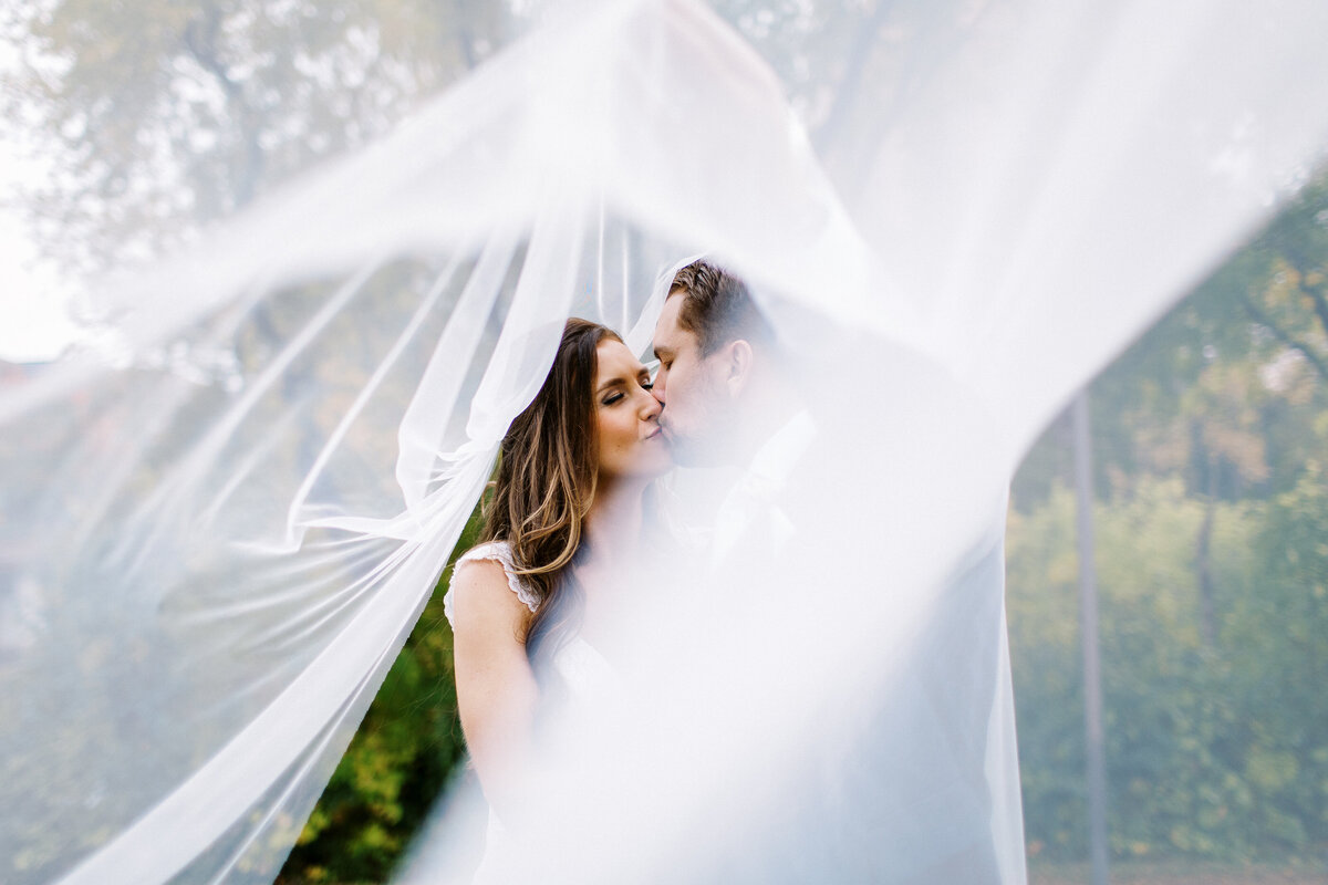 Newlyweds kissing under her vail