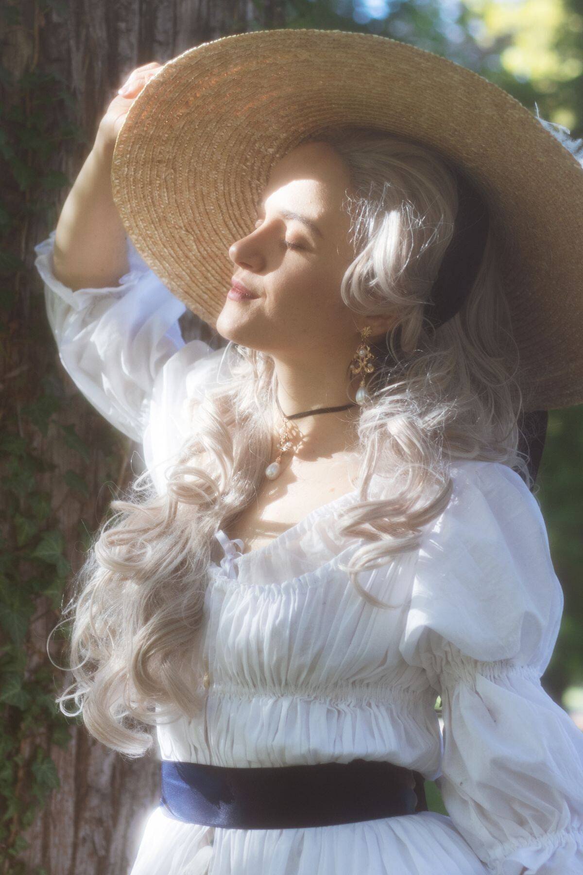 Portrait poétique d'une femme portant une tenue historique chemise à la reine ainsi qu'une perruque et un chapeau, lors d'une séance photo artistique à Voiron
