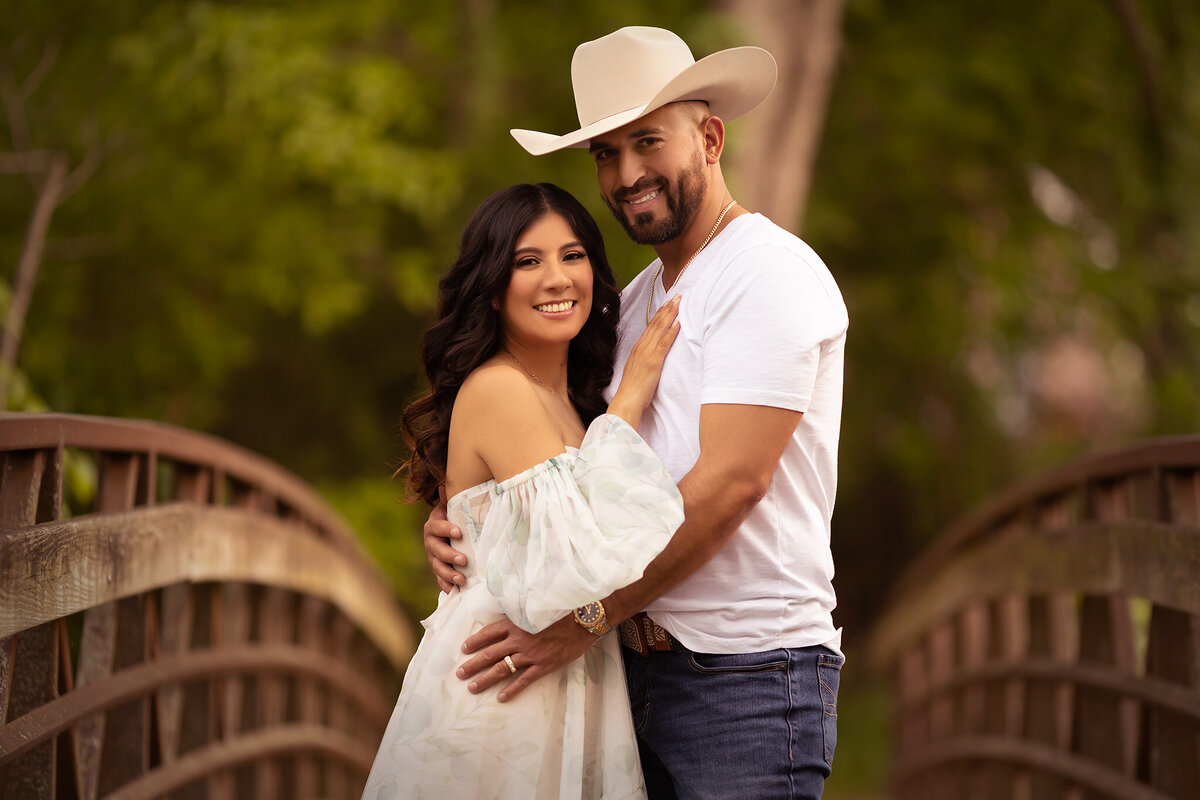 A couple embraces on a bridge, captured during a Dallas family portrait session, showcasing their love with Dallas family photography.