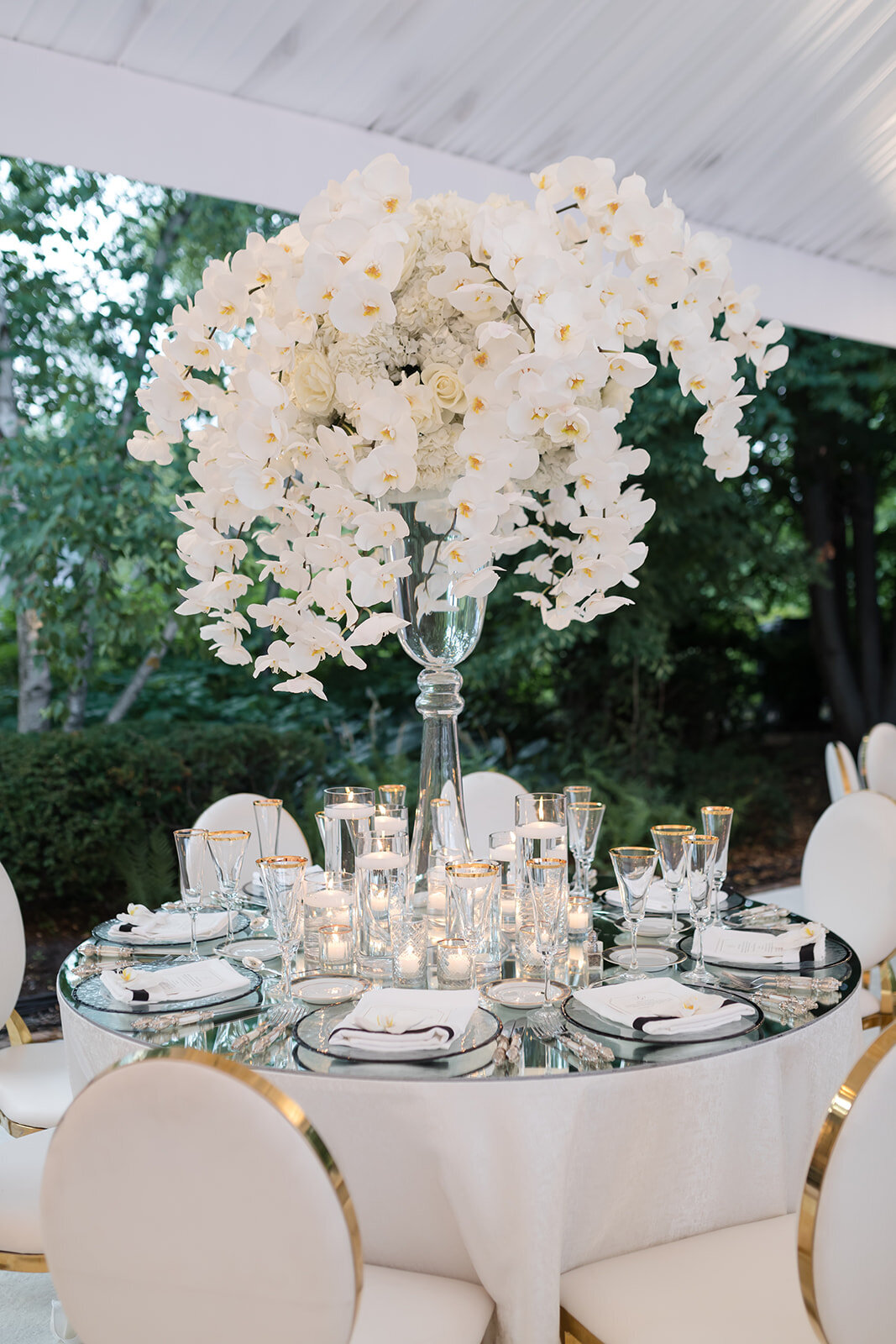 Elegant table setting with towering white floral centerpieces and candelabras.