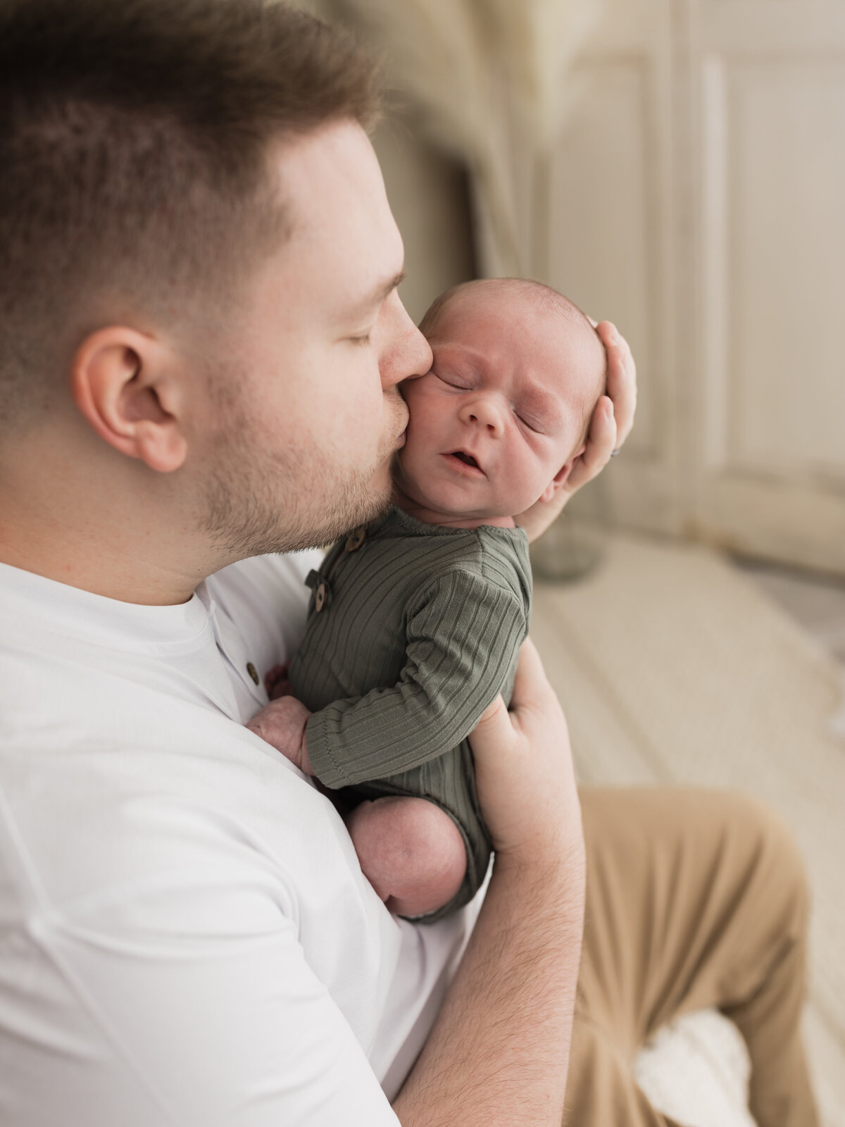 dad in white shirt kissing his newborn baby boy cleveland newborn photographer