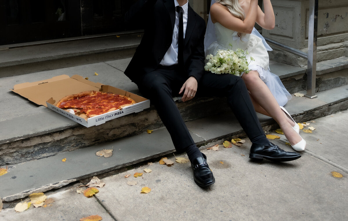The couple having a playful pizza night in NYC to celebrate their intimate elopement.