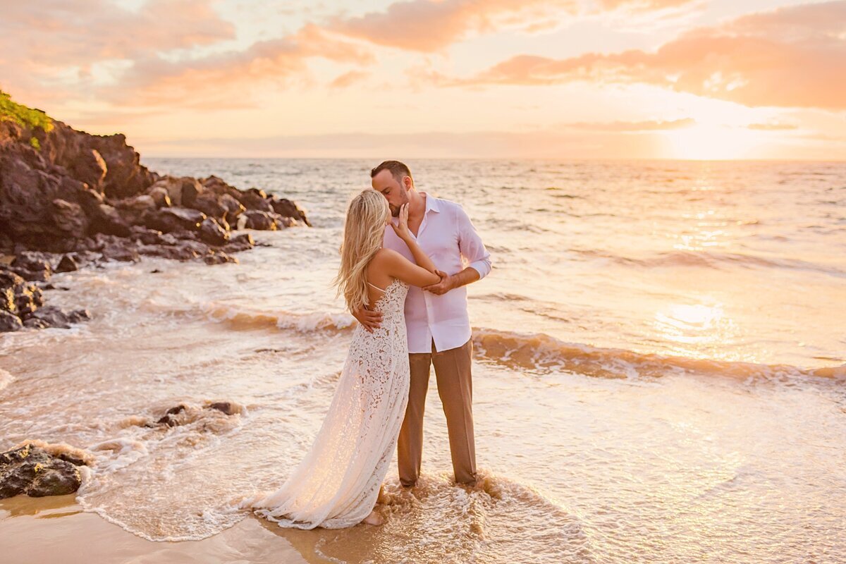 Beautiful couple kiss at sunset on the beach after a Maui proposal portrait session in Wailea with Love + water
