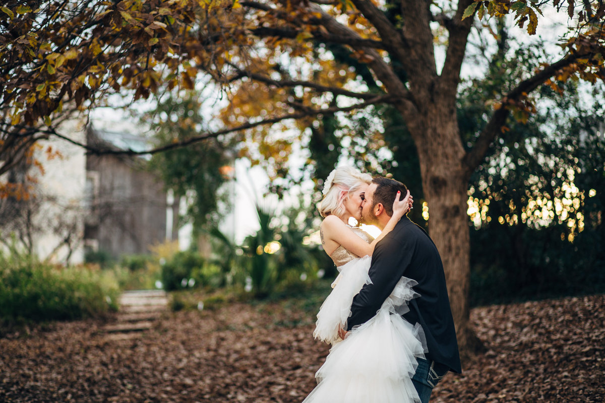Bride and groom kissing on the San Antonio Riverwalk after their wedding