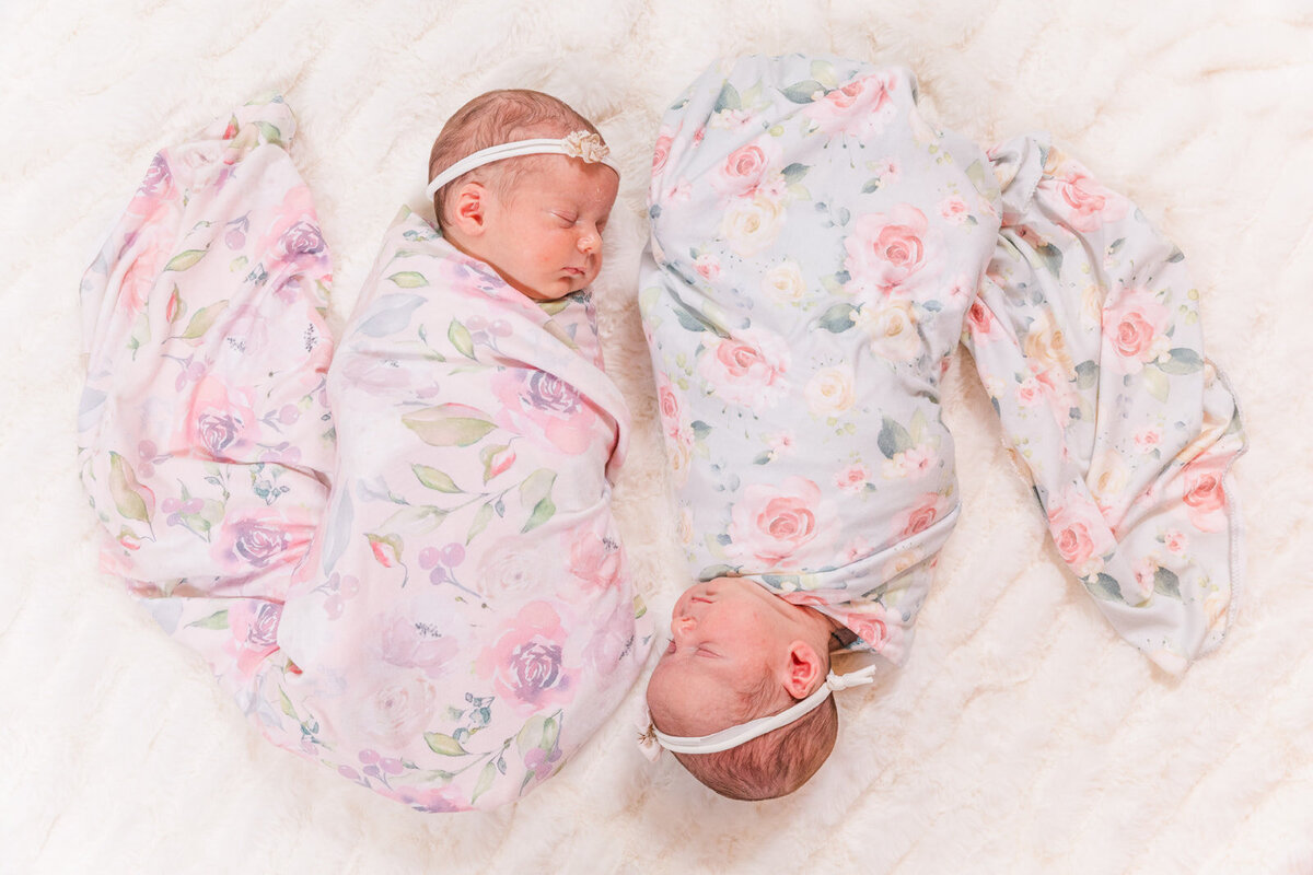 newborn twin babies wrapped sleeping on white blanket