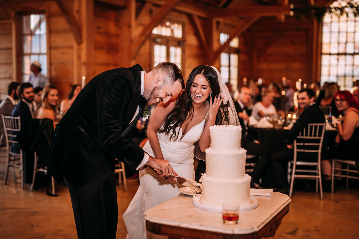 silly photo of couple cutting cake at stonehouse st charles wedding