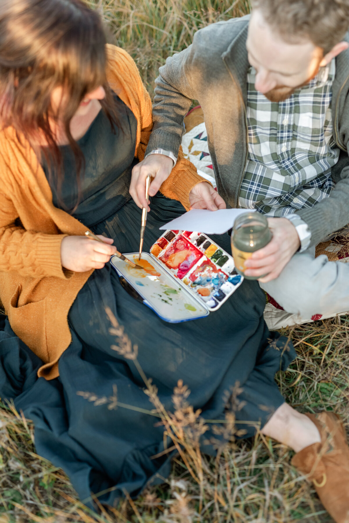 Stephanie & Dylan painting with watercolors together during their engagement session in Colorado