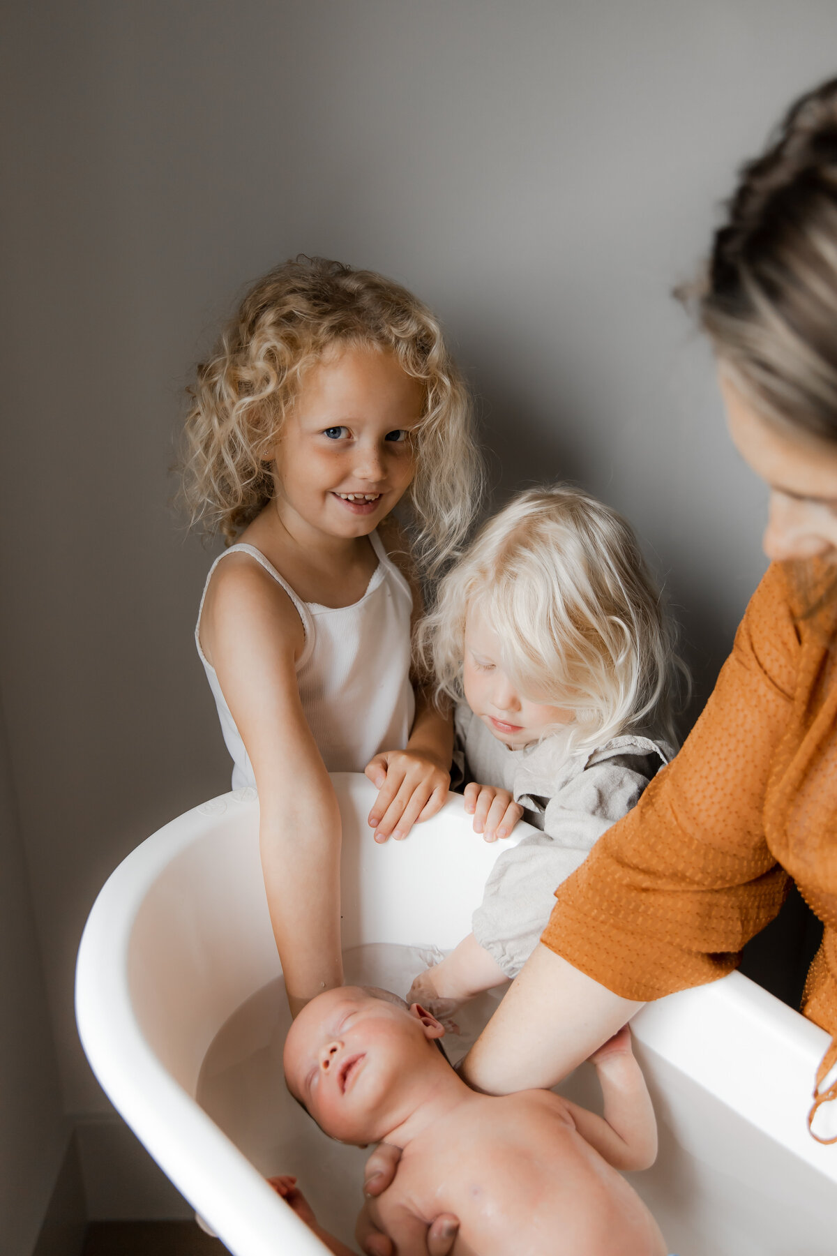 Kraamreportage zusjes en mama doen baby in bad