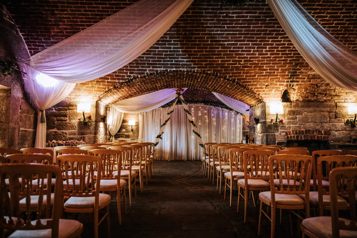 A room filled with lots of wooden chairs reay for a wedding ceremony