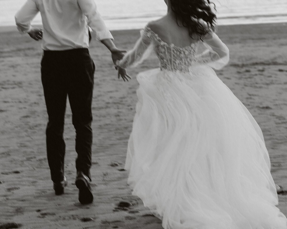 Black and white moments of Married couple having fun whilst being photographed on the beach