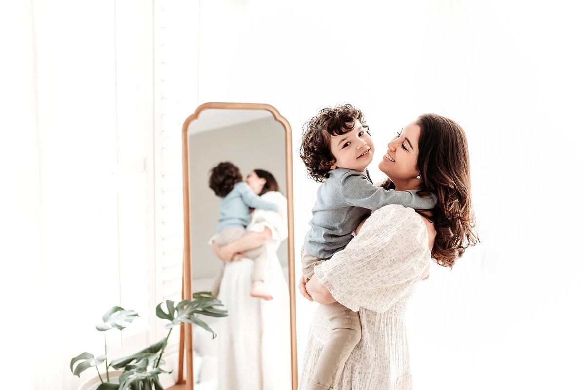 mother holding son in front of mirror by denver milestone photographer