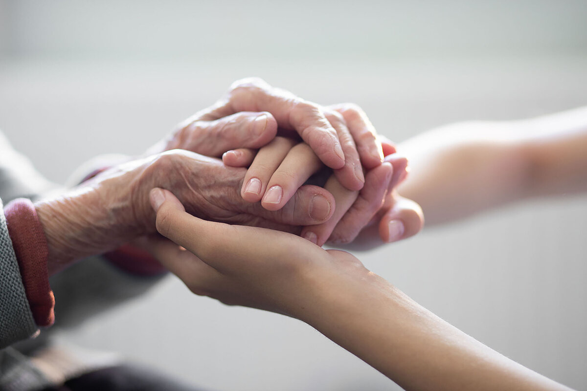 young hands holding elderly hands