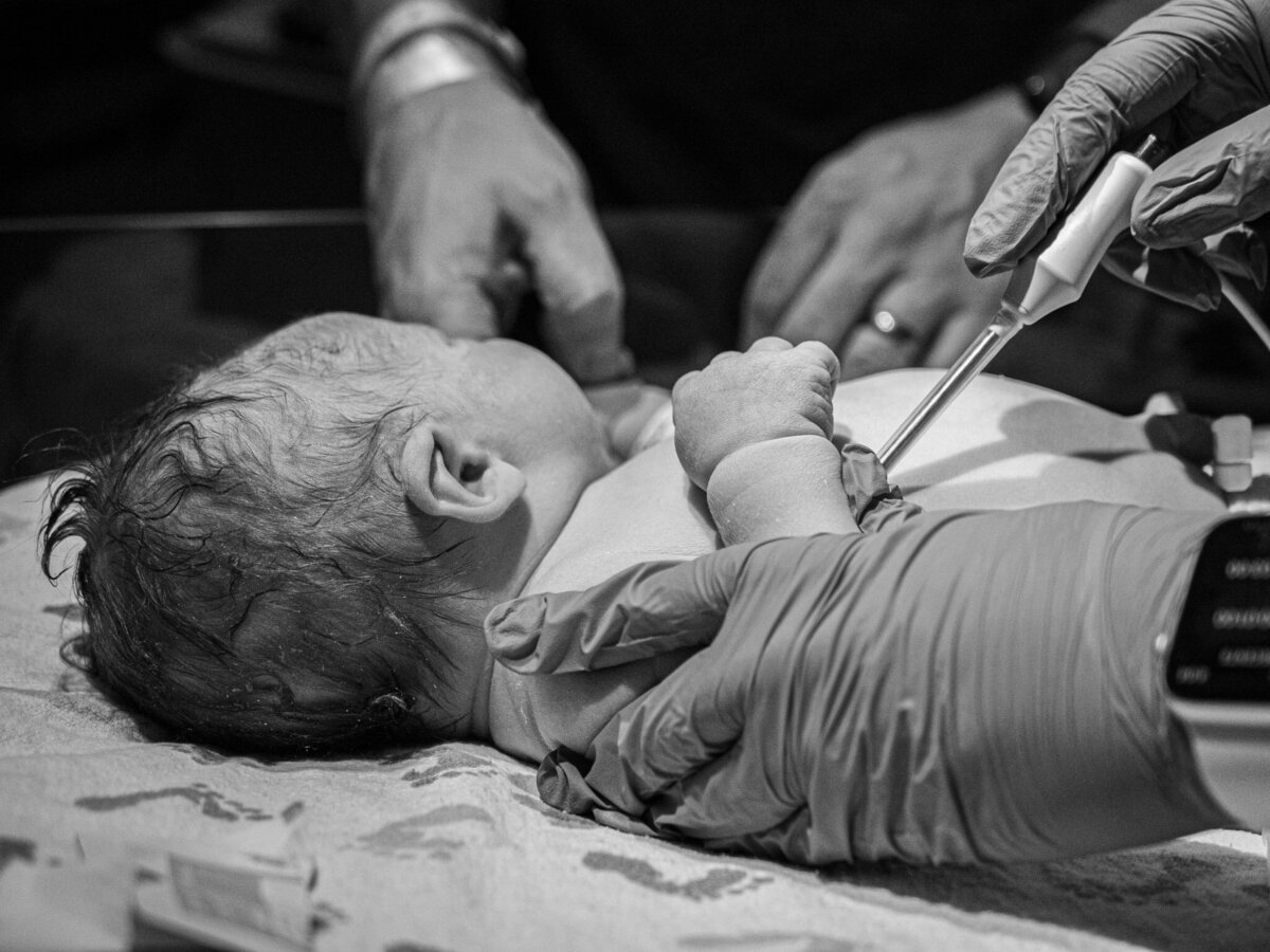 a nurse is taking the temperature of a newborn baby at OverLake Childbirth Center in Bellevue, Wa taken by seattle birth photographer, Becky Langseth.