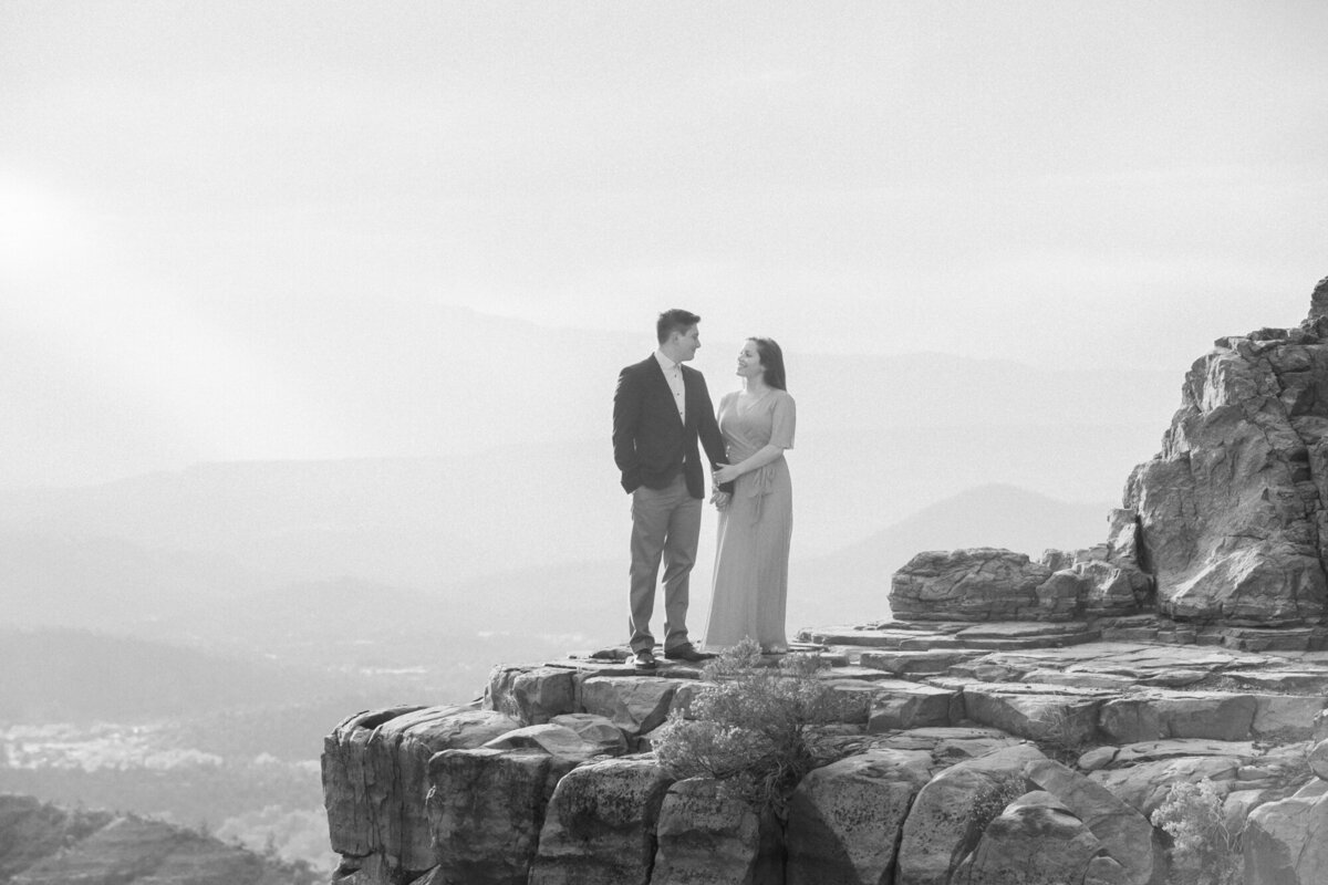 A black and white engagement photo taken at Cathedral Rock in Sedona at sunset.