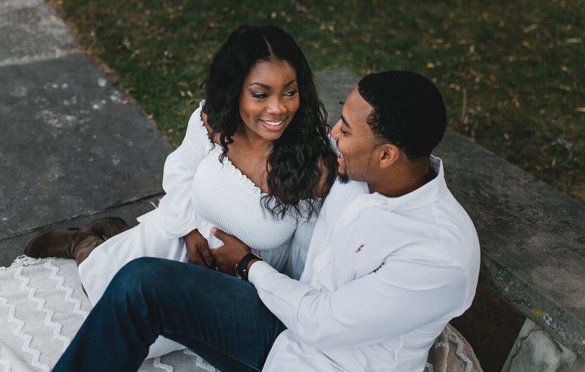 Pregnant woman sits next to a man on a bench.