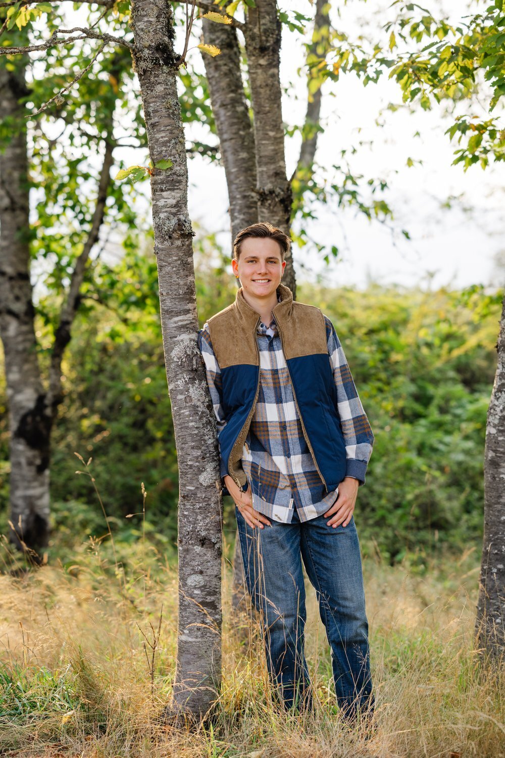 north bend senior guy leaning against tree