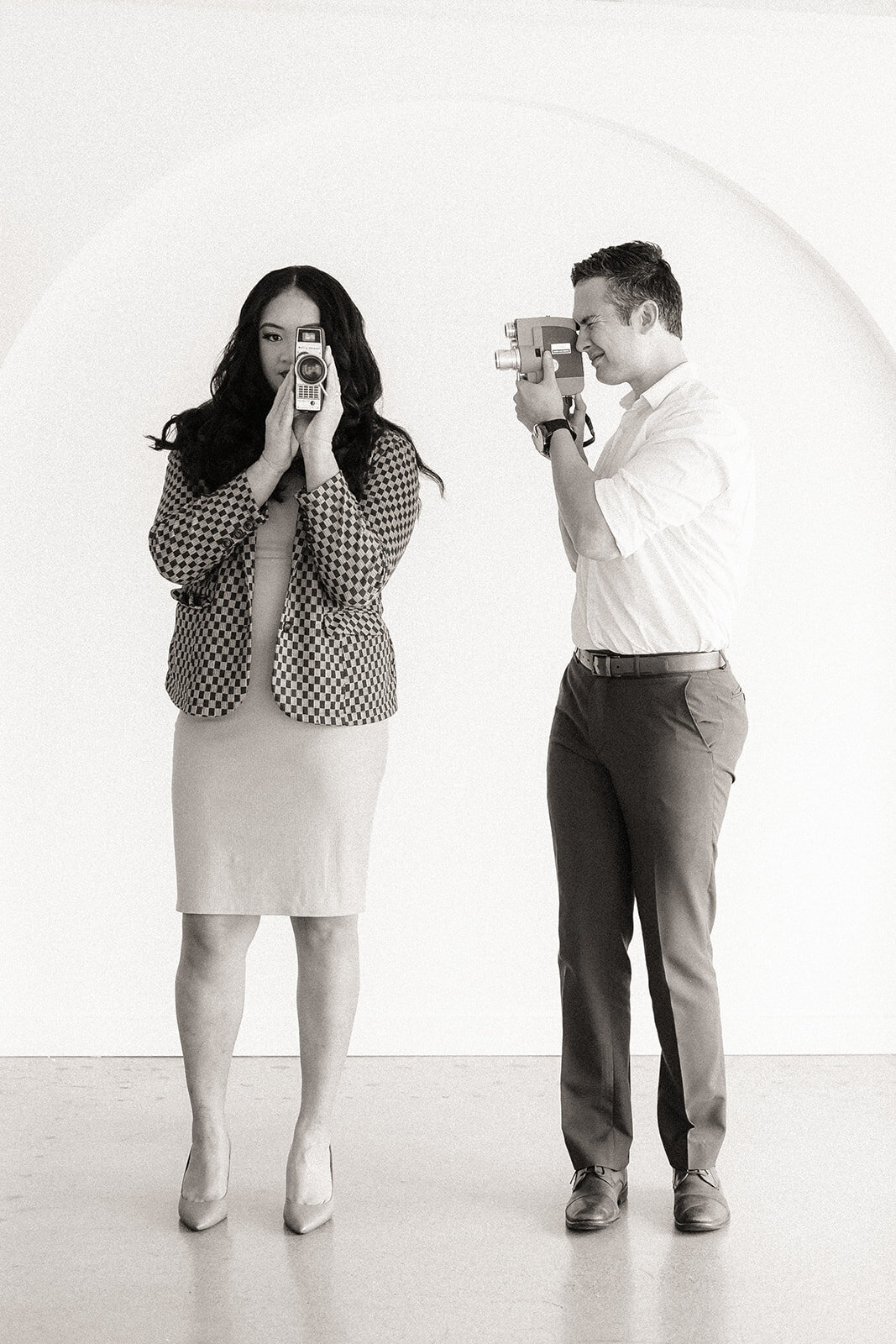 Two people hold cameras