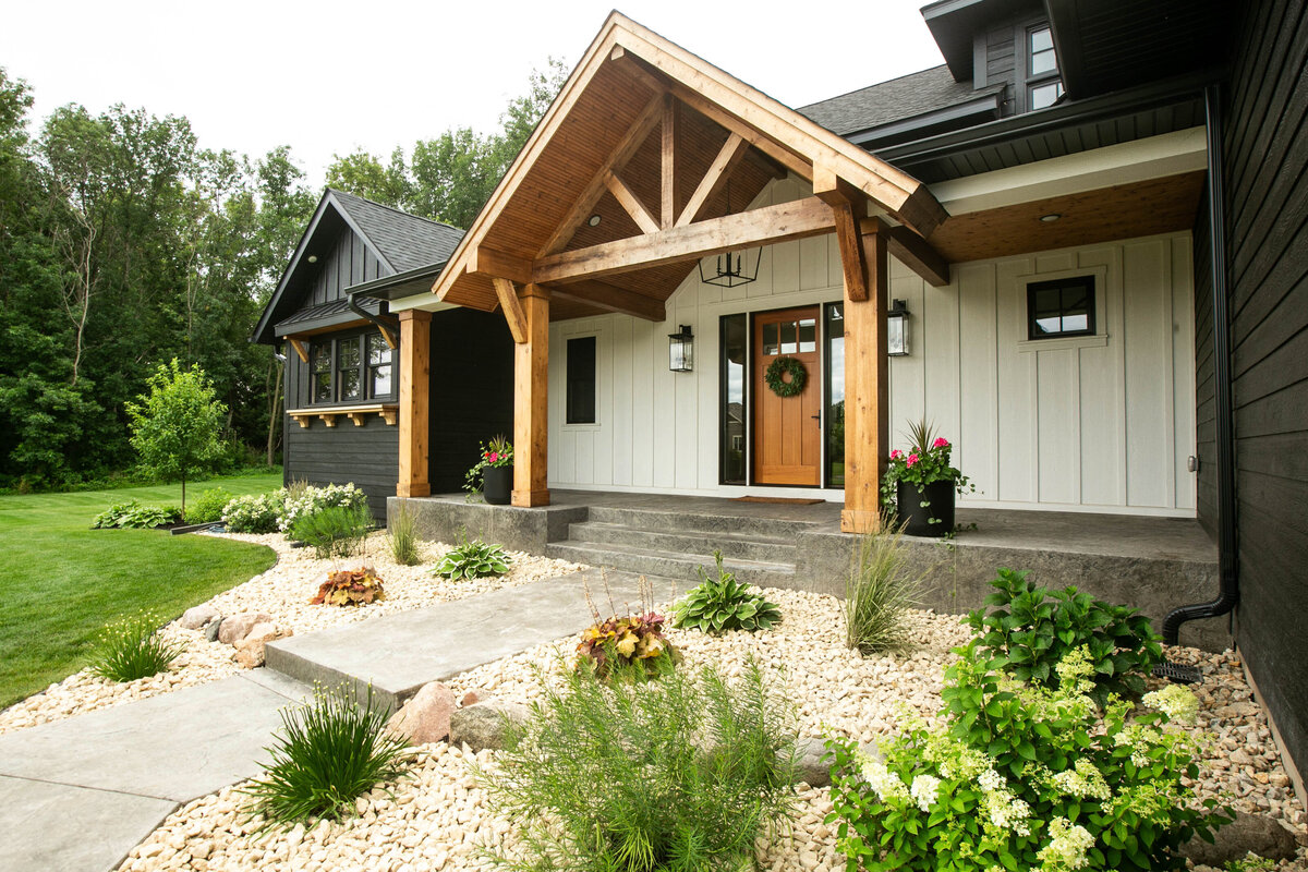 Exterior view of custom home in Otsego, Minnesota with modern wood details and front porch built by Cornerstone Custom Builds