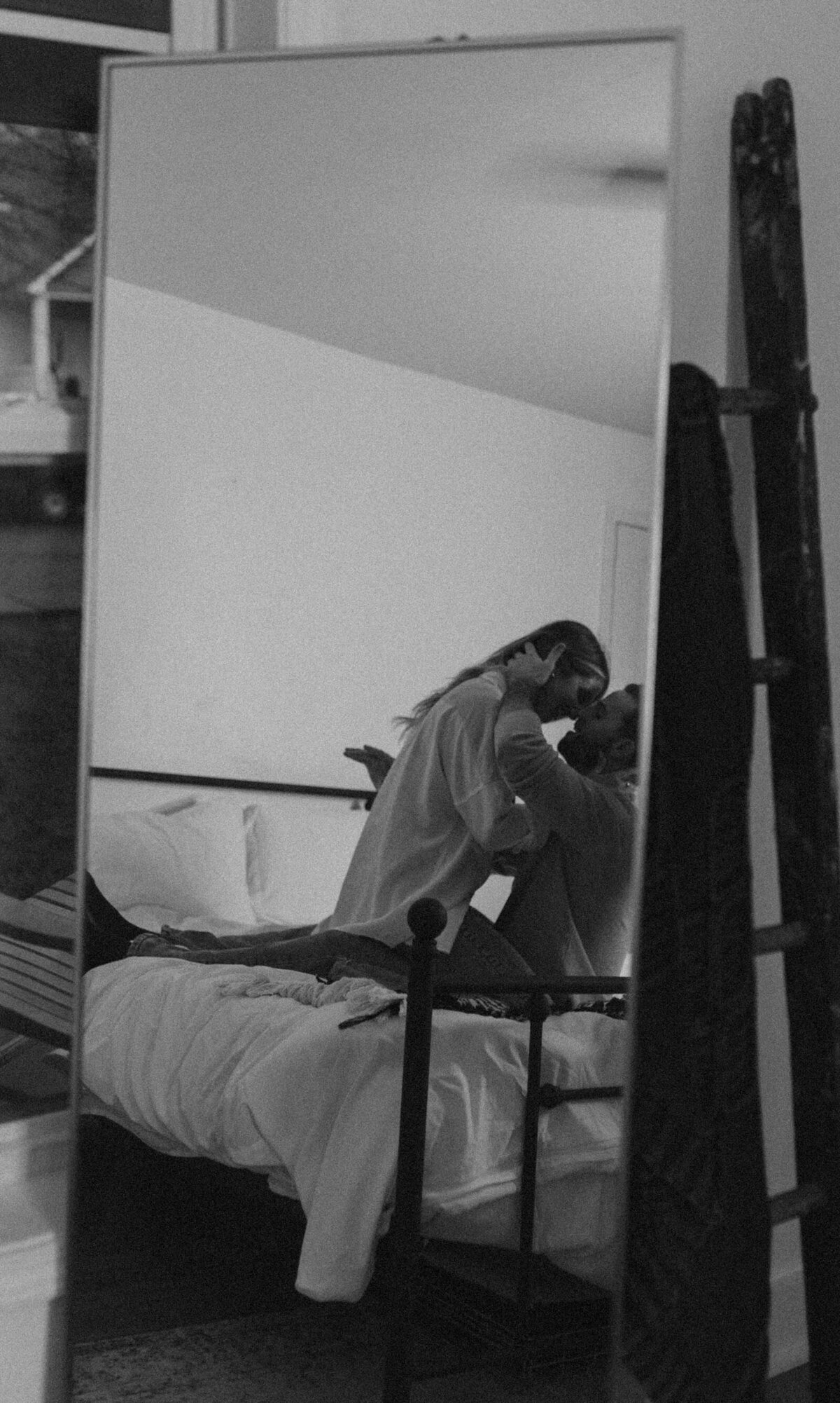 Couple kissing off-camera on their bed