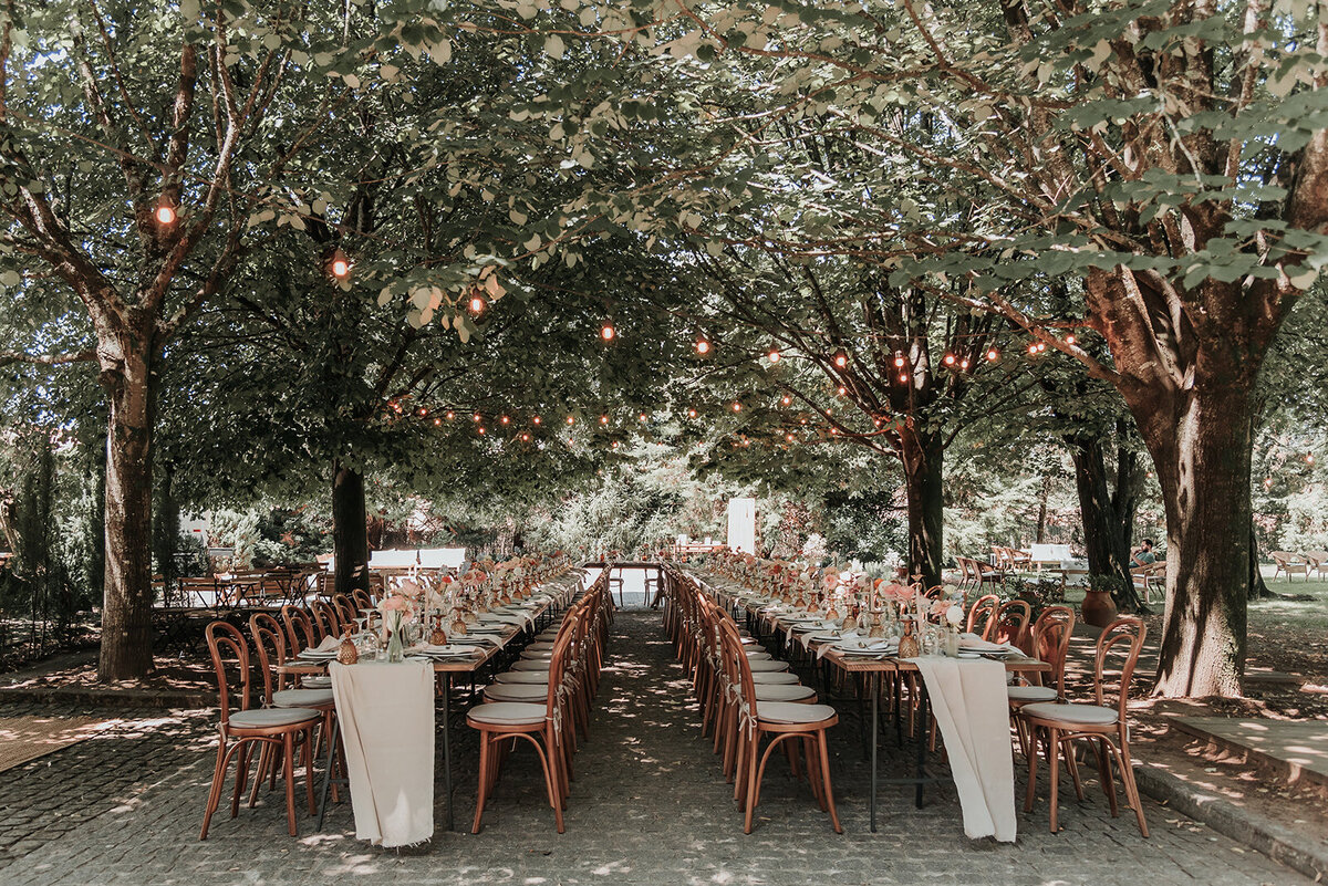 Beautiful long wedding table set up under the trees with fairy lights at Casa Grande de Fontao, Portugal