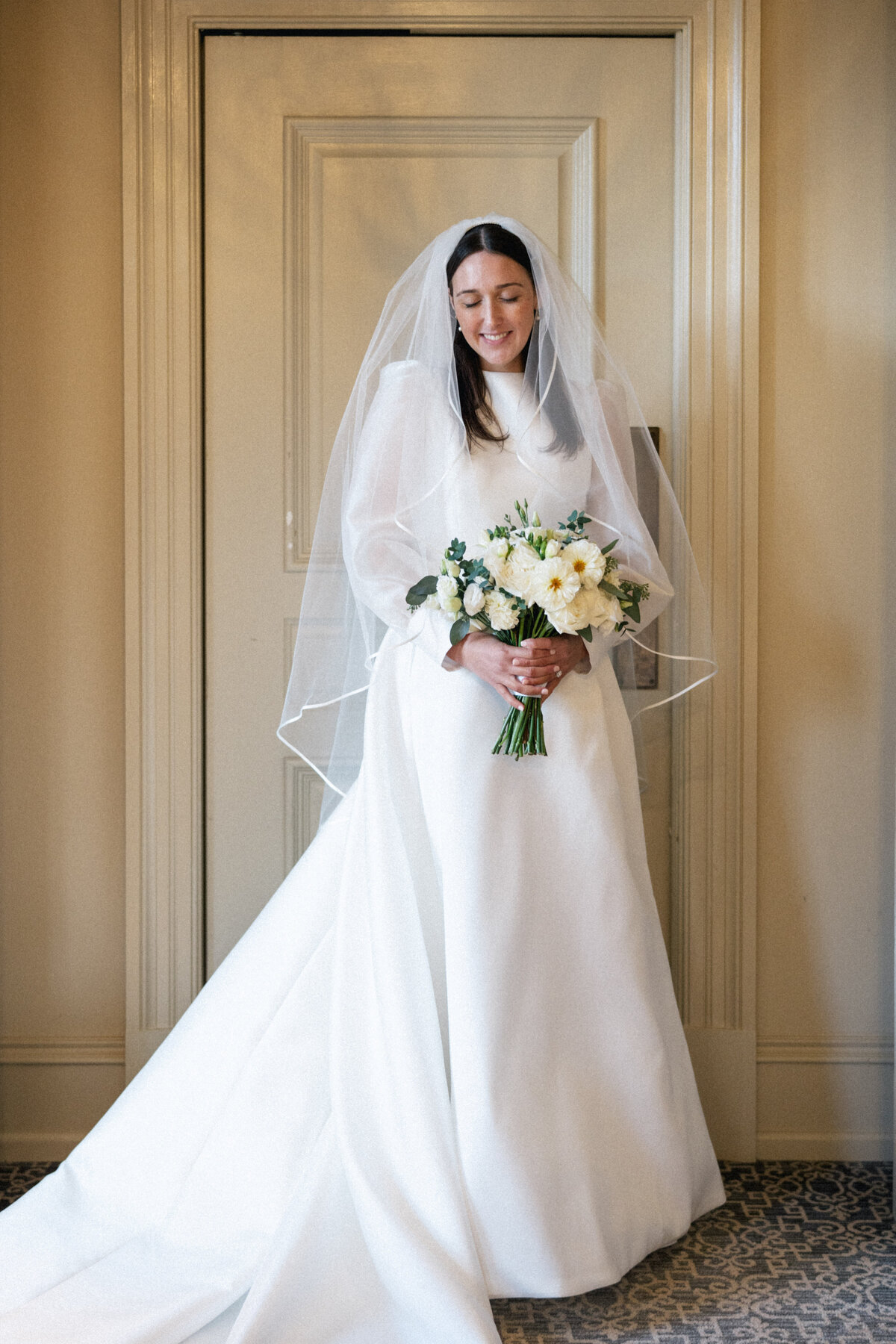Bride in long sleeve wedding gown holding bouquet at late fall Cleveland wedding.