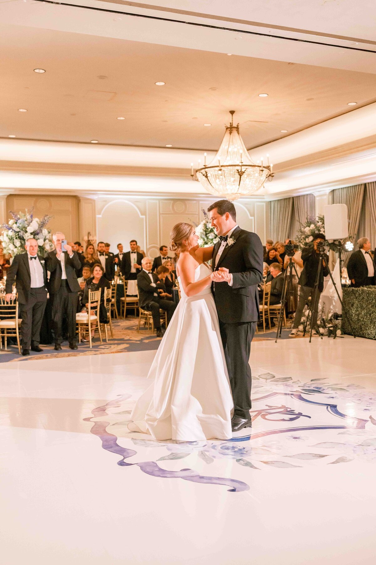 bride and groom share their first dance on the dancefloor at their first wedding reception