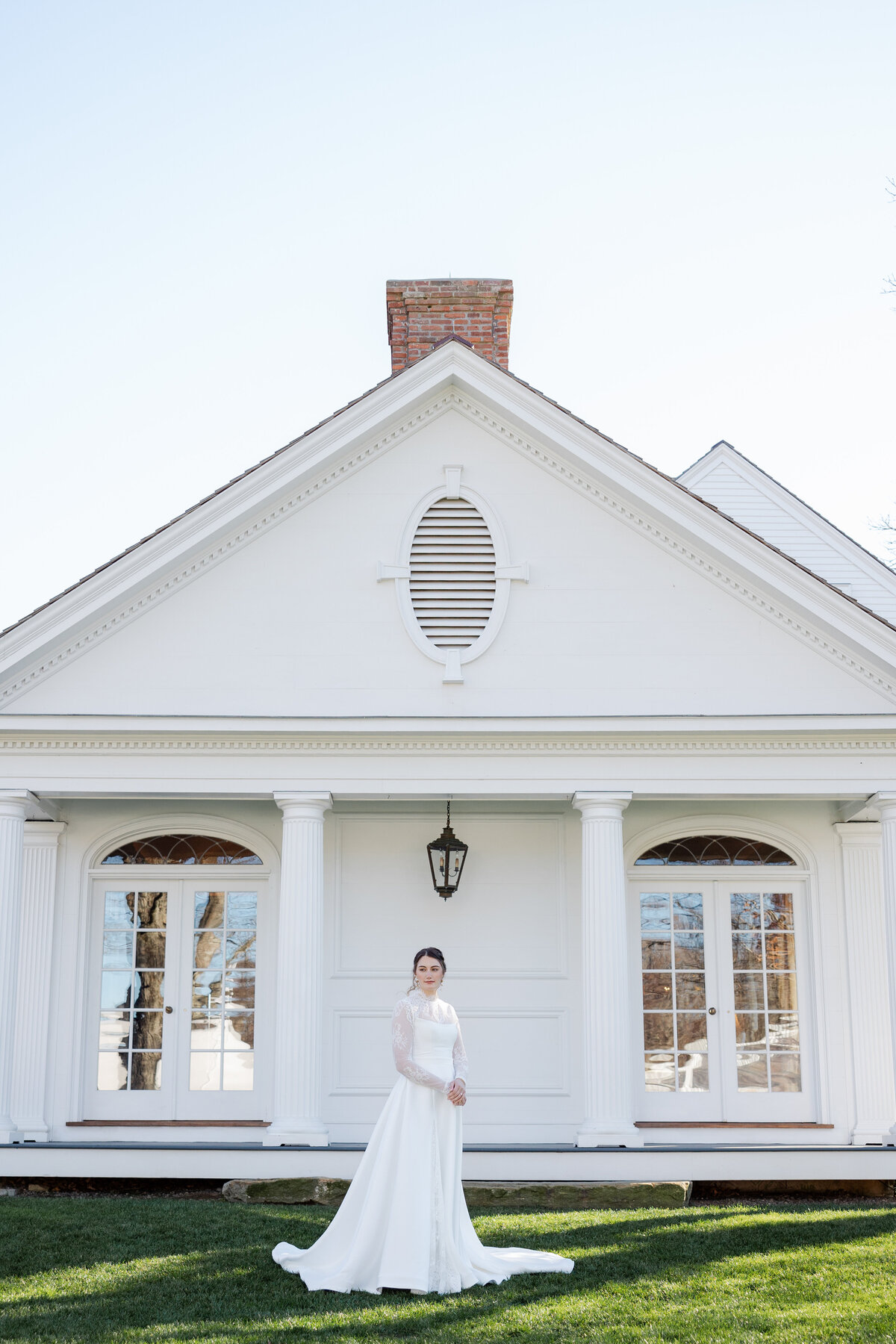 A Bride in her dress standing in front of Smith Farm Gardens In Connecticut.