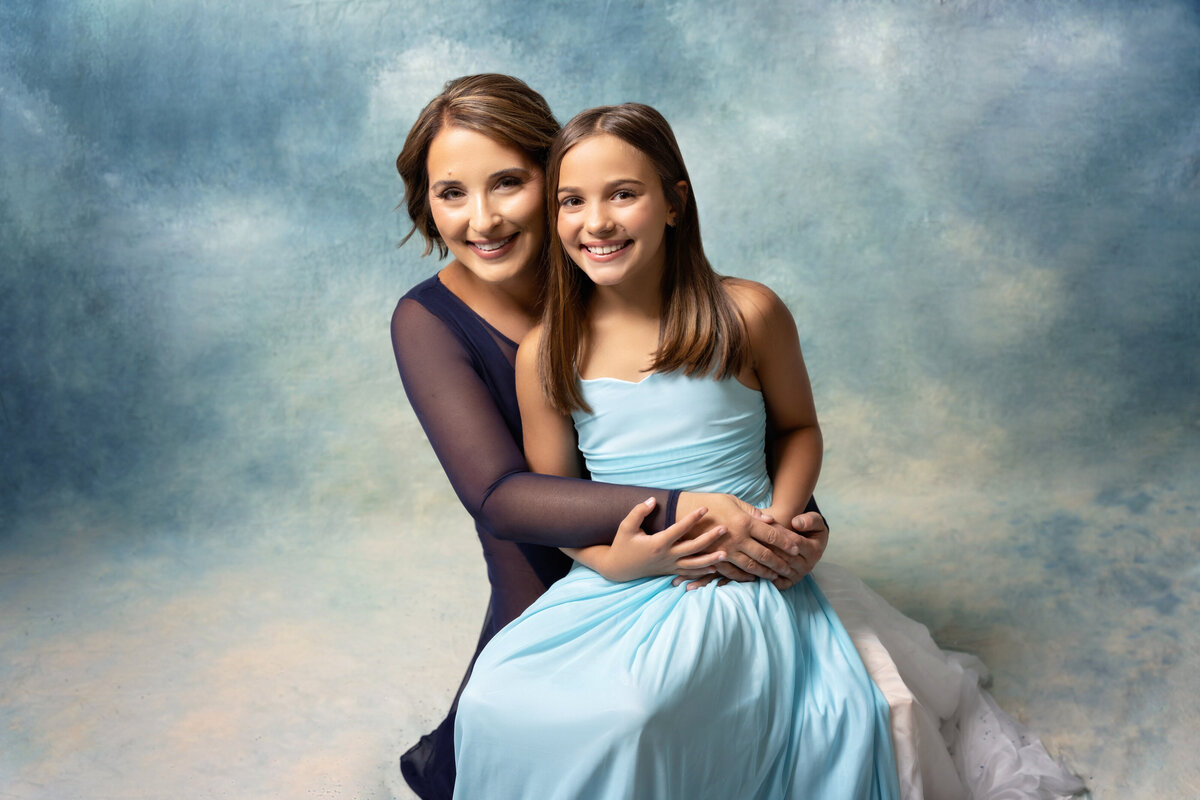 mom daughter blue studio New Orleans hug clouds
