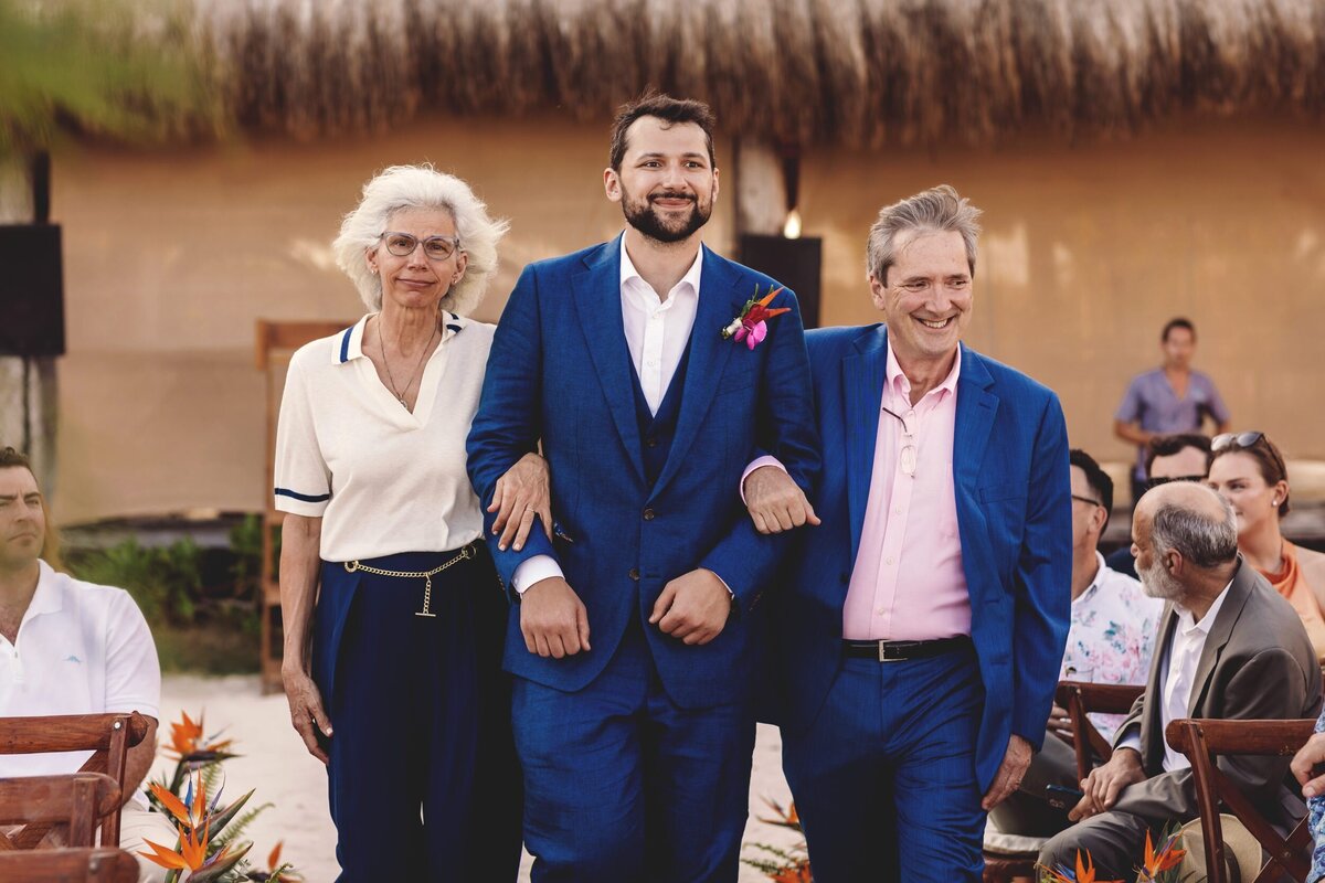 Groom walking down aisle with parents at Blue Venado Seaside Riviera Maya wedding