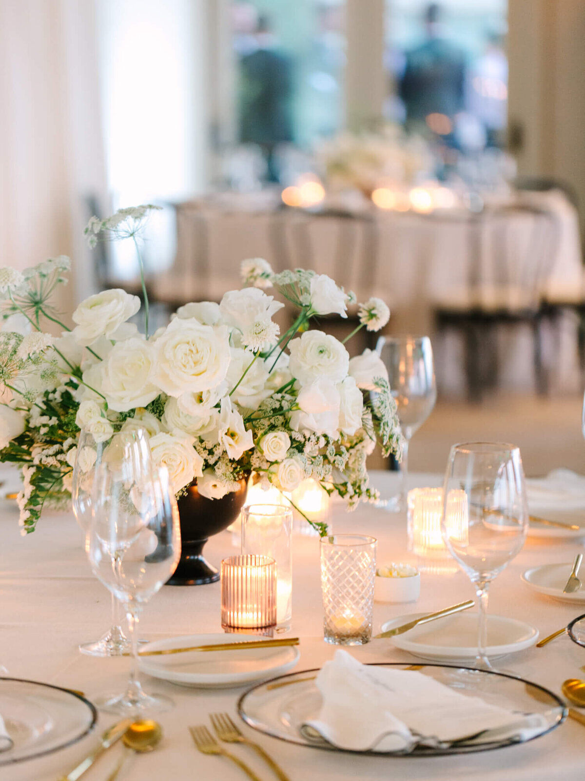 indoor wedding reception shot of flowers and place settings