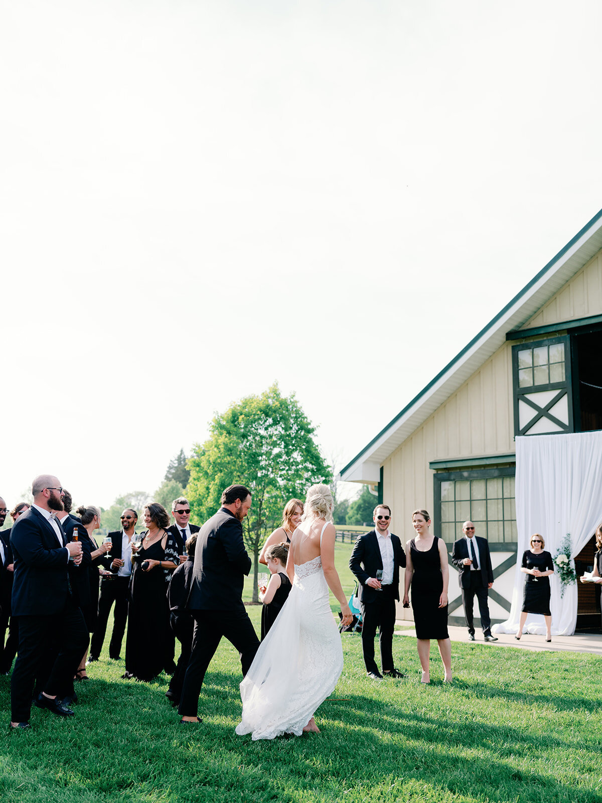 Bride and groom walk in towards stables for their wedding reception at salamander resort