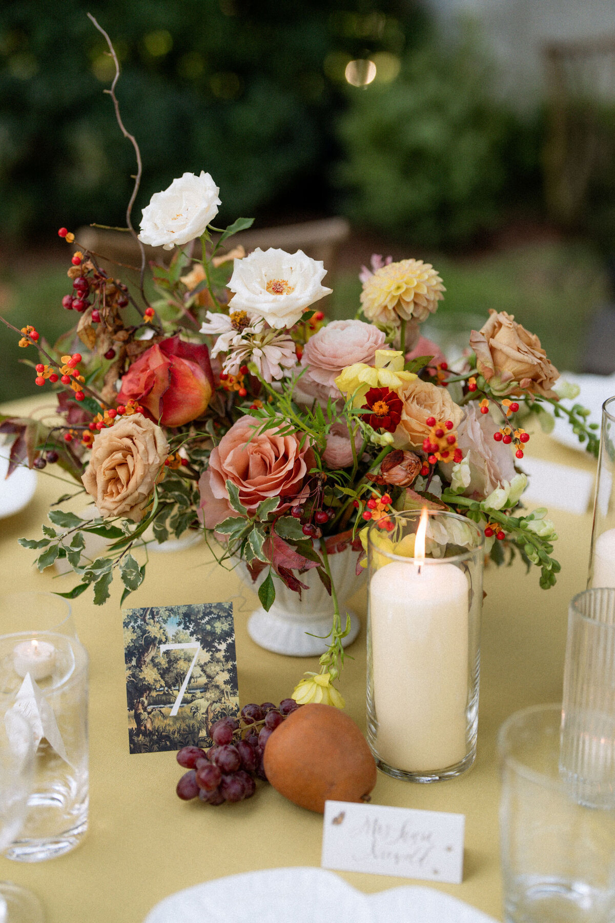 Lush fall florals for low and high centerpieces at fall wedding reception. Clear tented wedding reception in the family's back yard creating an intimate wedding reception environment. Whimsical and organic floral design in colors of copper, yellow, blush,and brown. Fall florals with sweet peas, dahlias, butterfly ranunculus, roses, mums, and bittersweet berries. Design by Rosemary & Finch Floral Design in Nashville, TN.