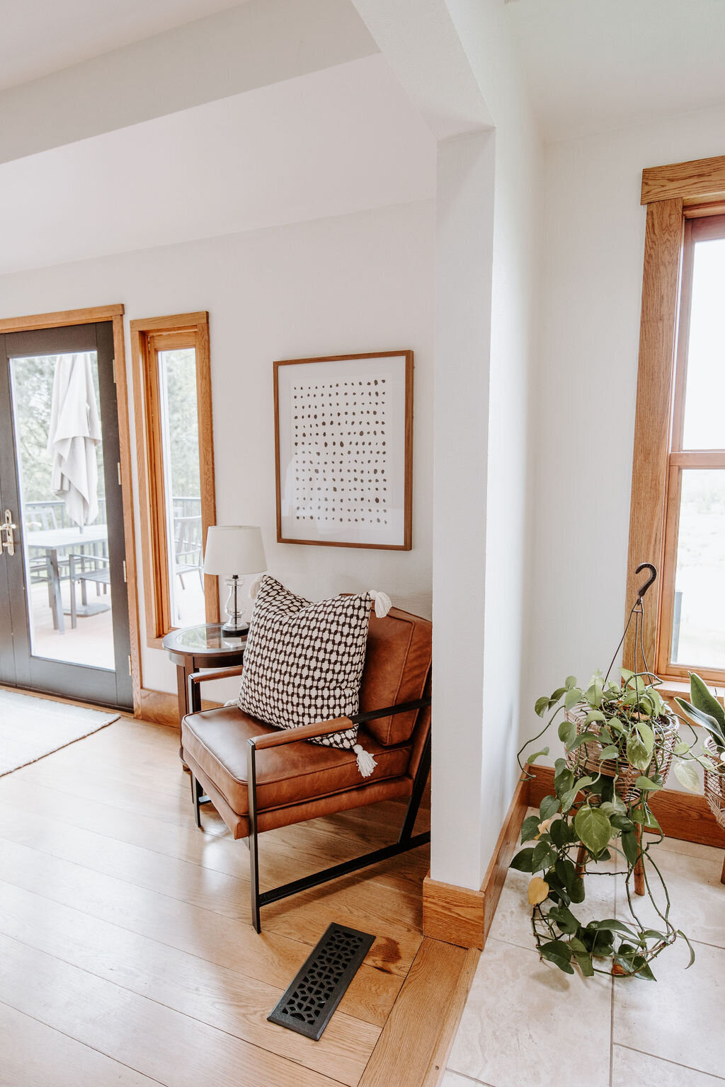 the patio doors leading to the deck with a leather chair and CB2 pillow in the modern farmhouse at Willowbrook wedding venue