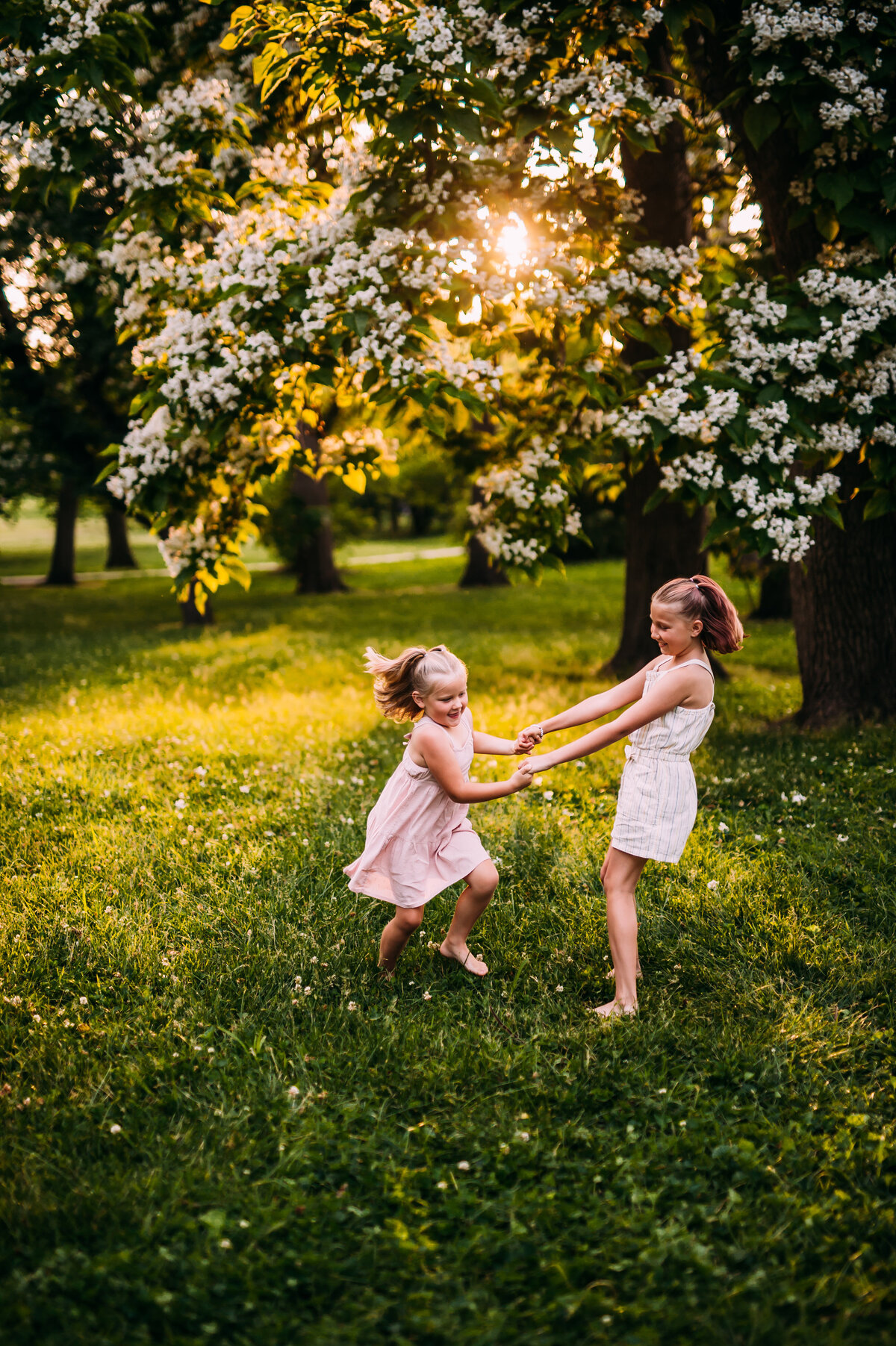 sisters under a blooming tree in spring in Missouri