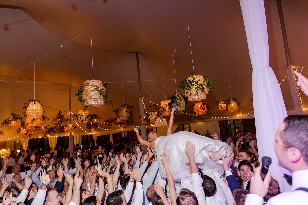 bride being lifted up on dance floor during reception 