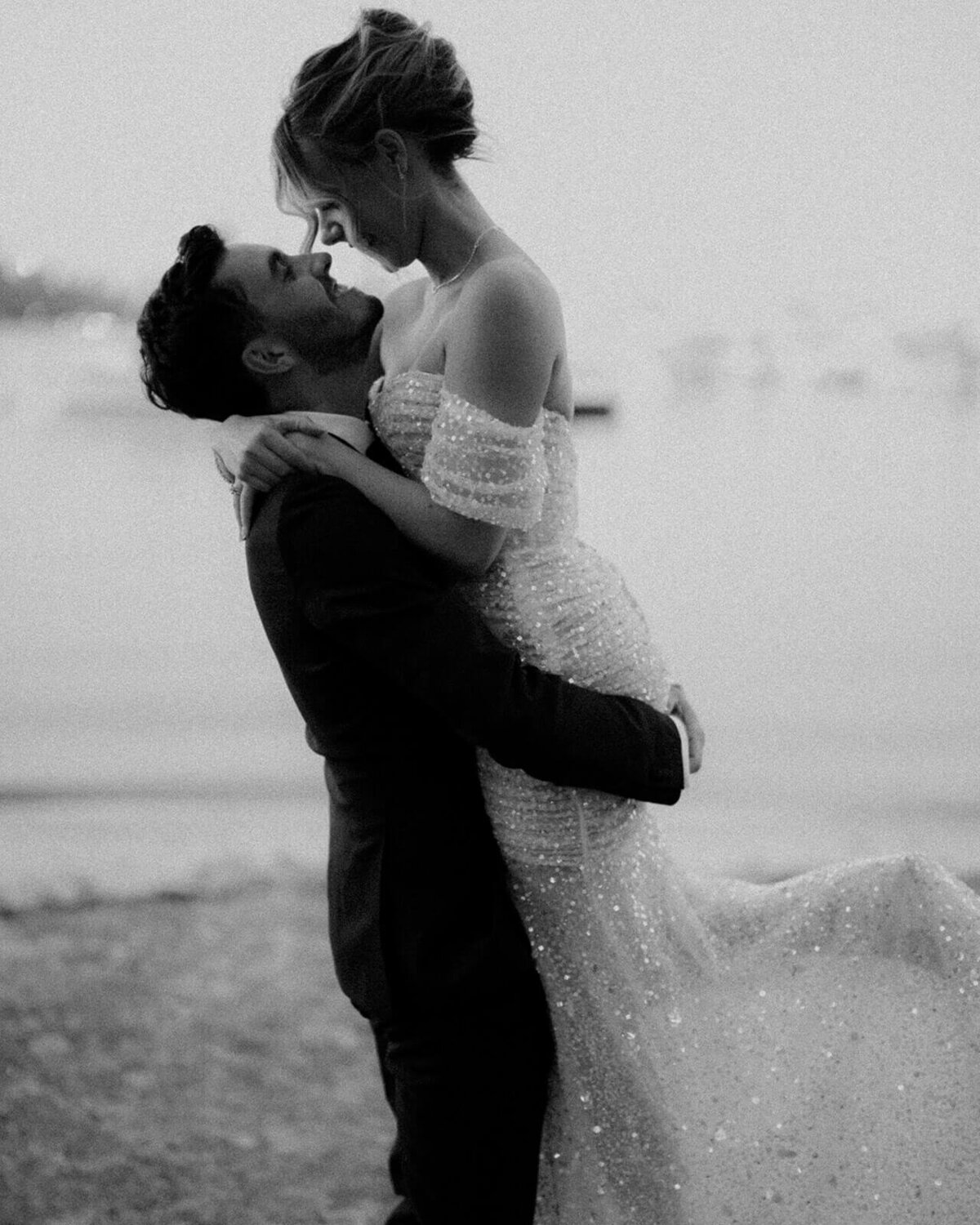 Groom lifting the bride, kissing in front of Matilda Bay on the swan river