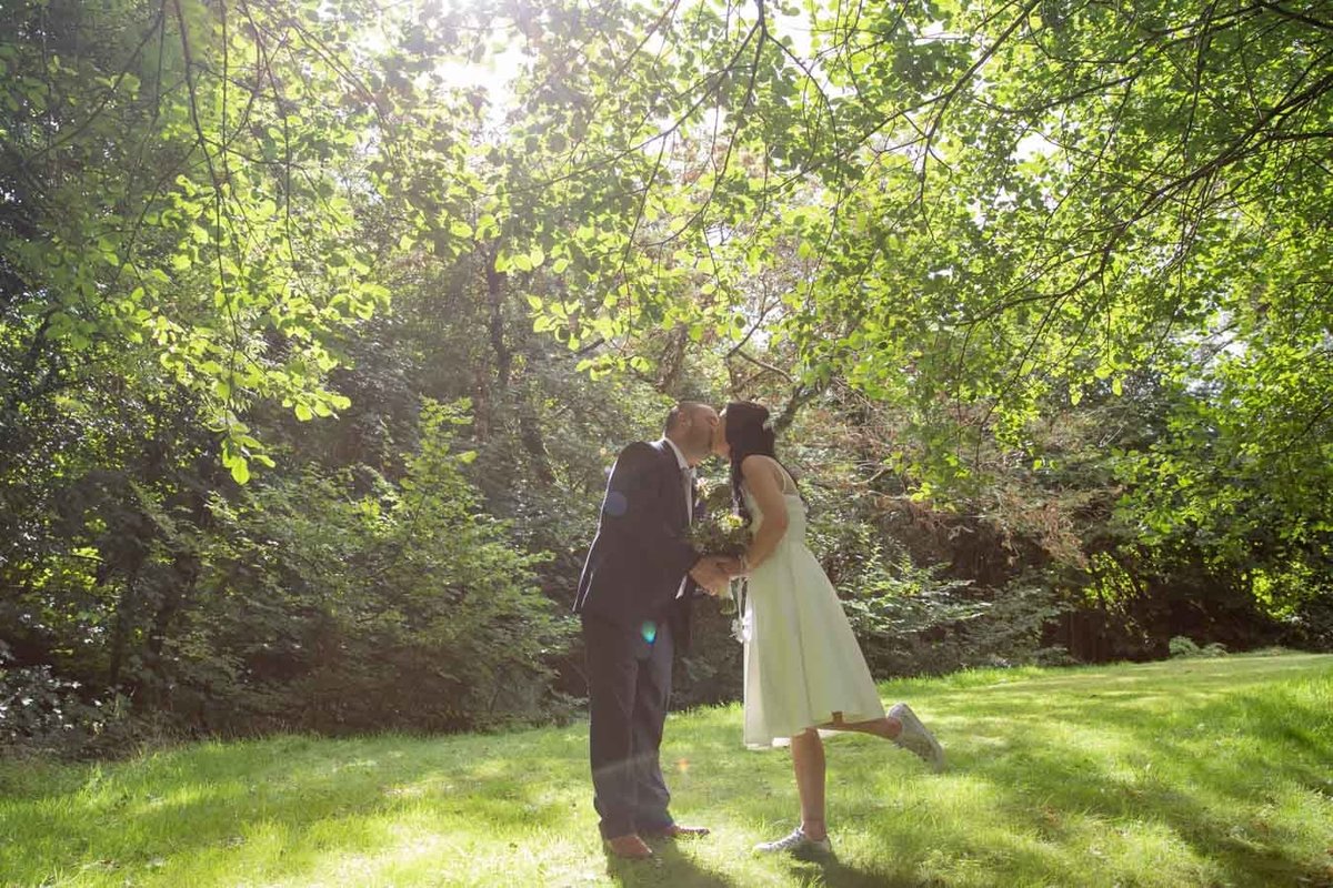 Elopement wedding couple at The Green Cornwall kissing under a tree