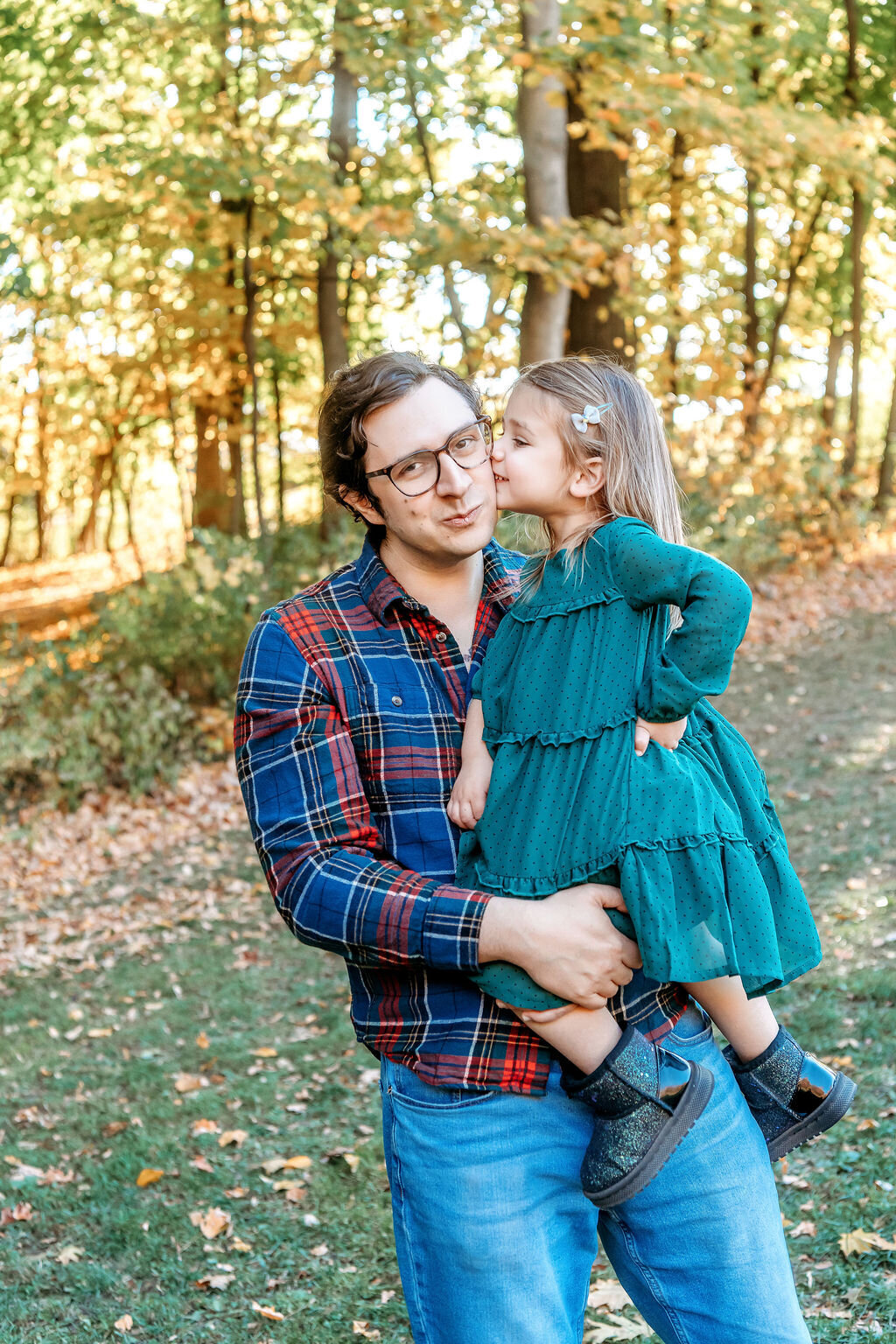 Father holding daughter in teal dress whispering secrets during Connecticut family photographer autumn portrait session
