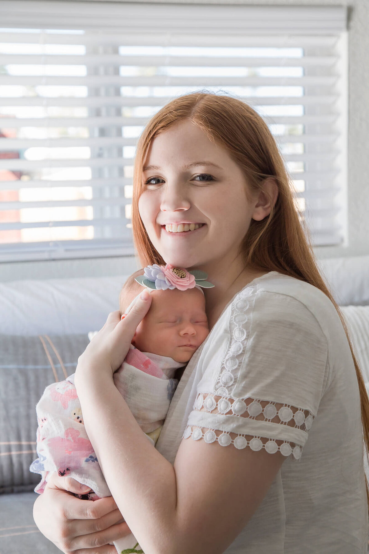 new mother holding her newborn baby girl asleep  on her chest