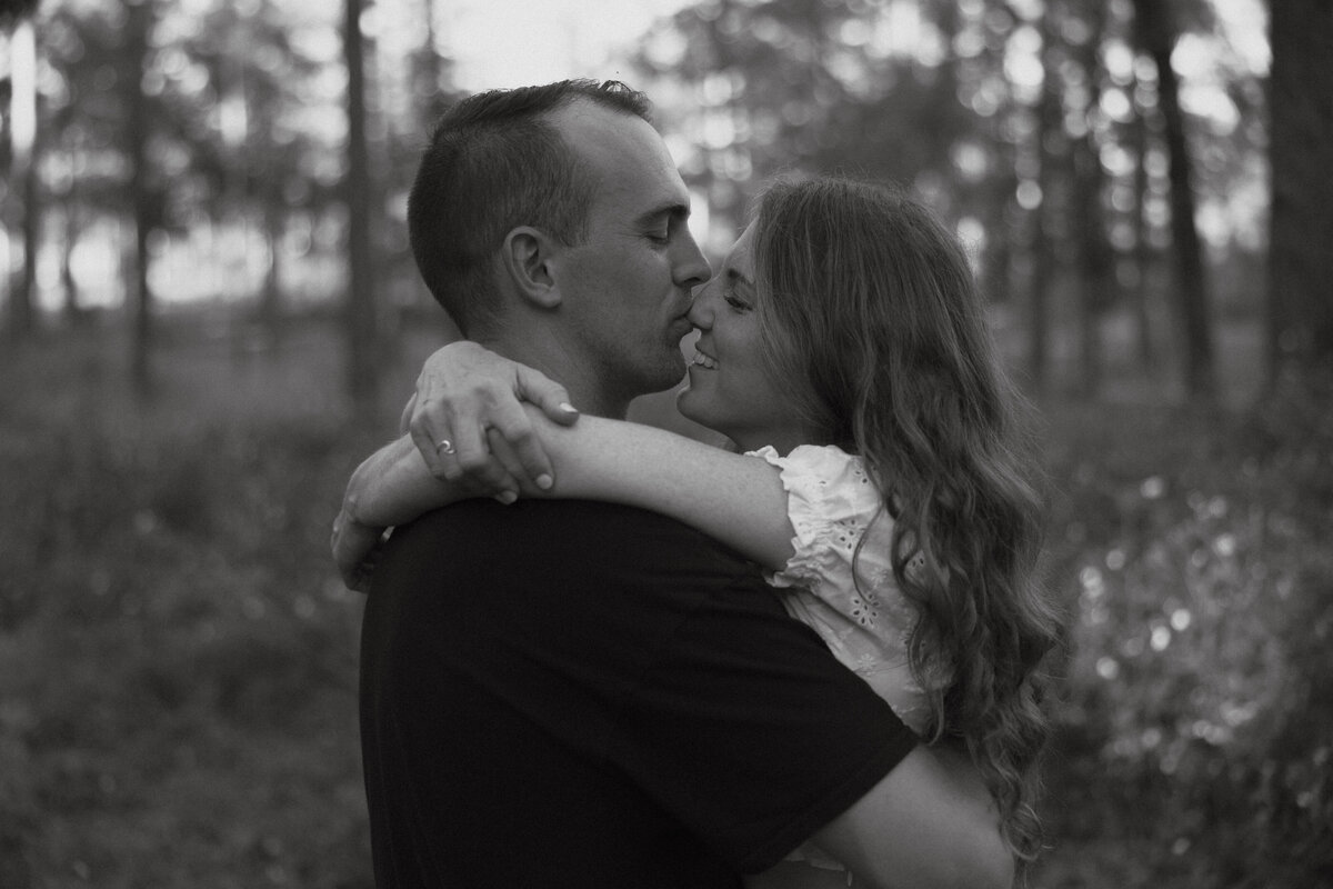Couple posing for portraits in a forest.