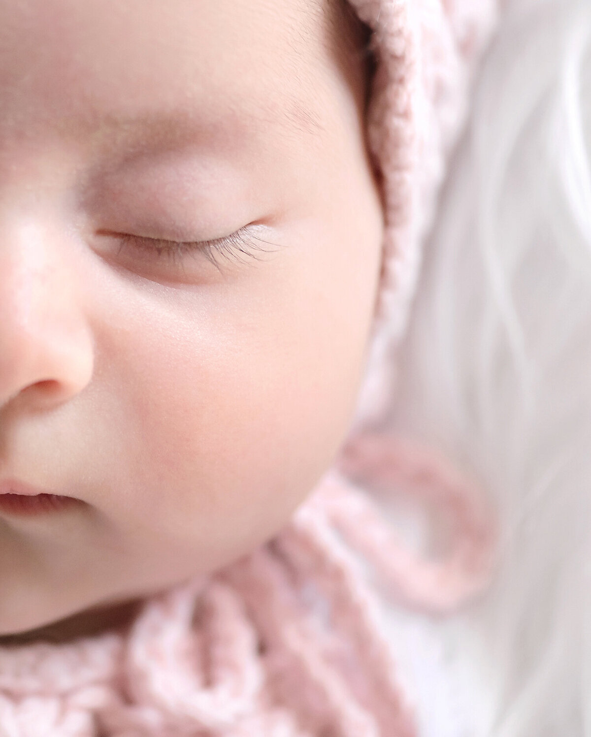 A detail close up image of a newborn baby girl's long eyelashes.