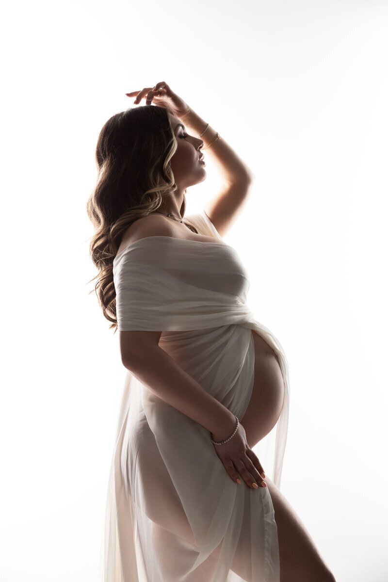 pregnant woman wearing sheer dress framing bump, by photographers new jersey Ally Kimpton Photography