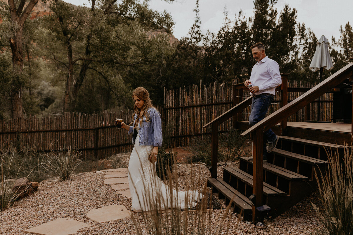 bride and groom walking down outdoor stairs of their cabin