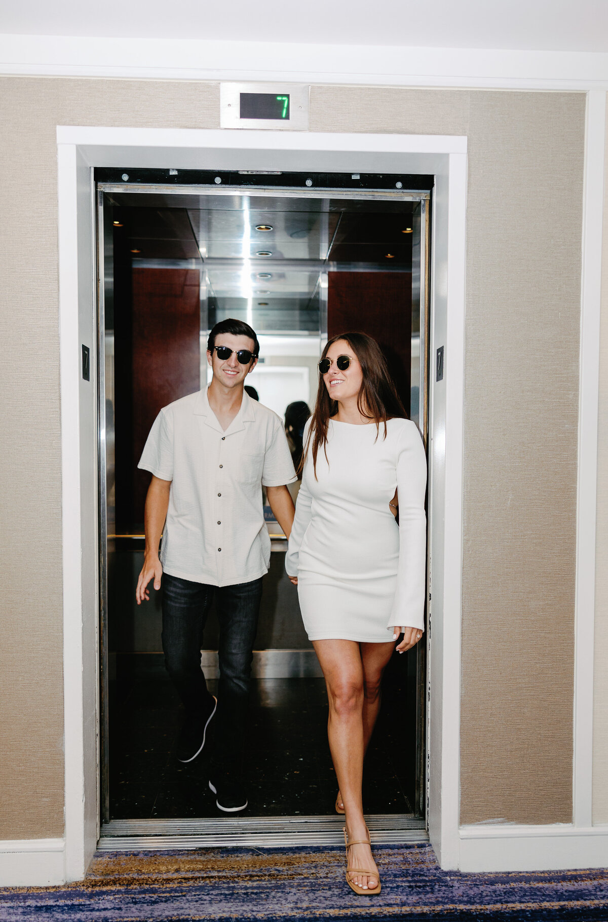 Couple exiting an elevator in color, captured by Miami wedding photographer Claudia Amalia, highlighting her wedding photography services.