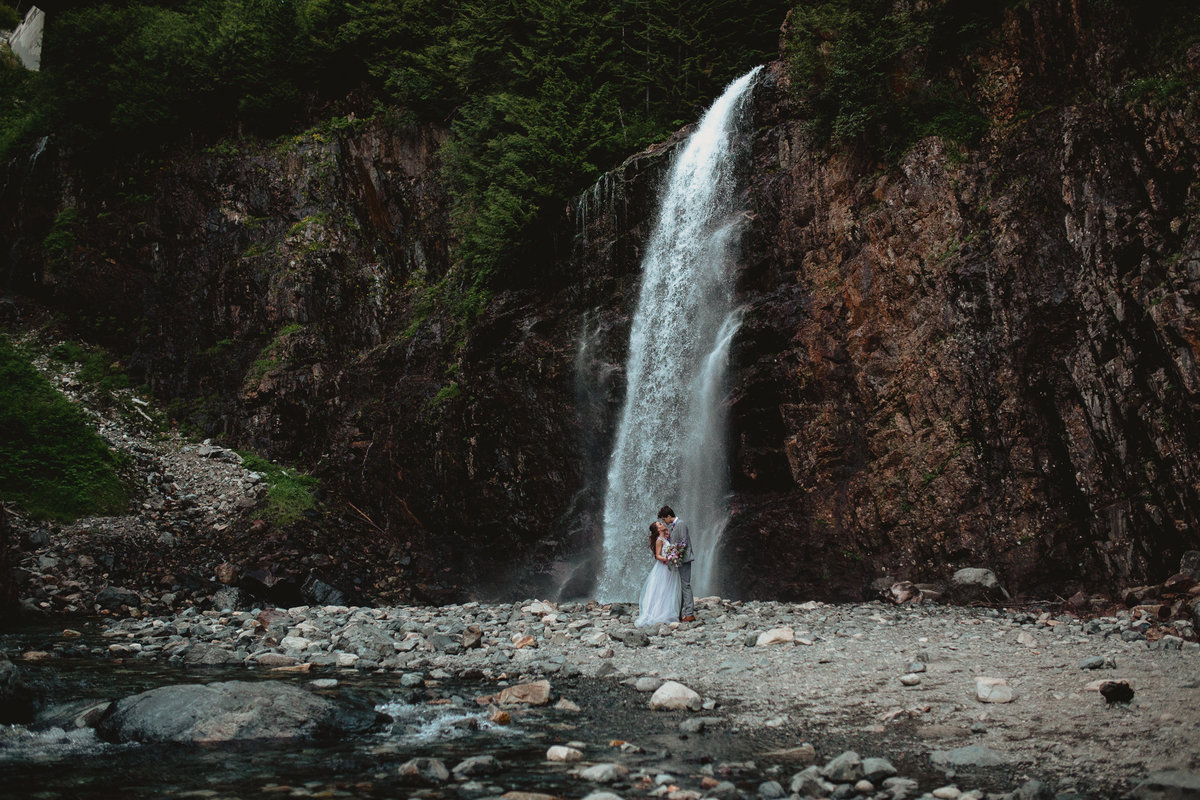 Epic elopement wedding in front of a waterfall in the Pacific Northwest during their elopement wedding outside of Seattle Washington